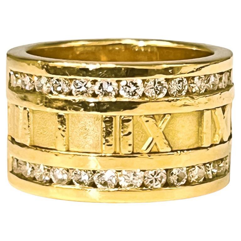 Tiffany & Co 18k yellow gold wide gold band ring, featuring a central row of Roman numerals and a double border of twenty-eight round brilliant-cut diamonds weighing approximately 0.56 total carats (going half way around).  Finger size 6 1/4.  12mm