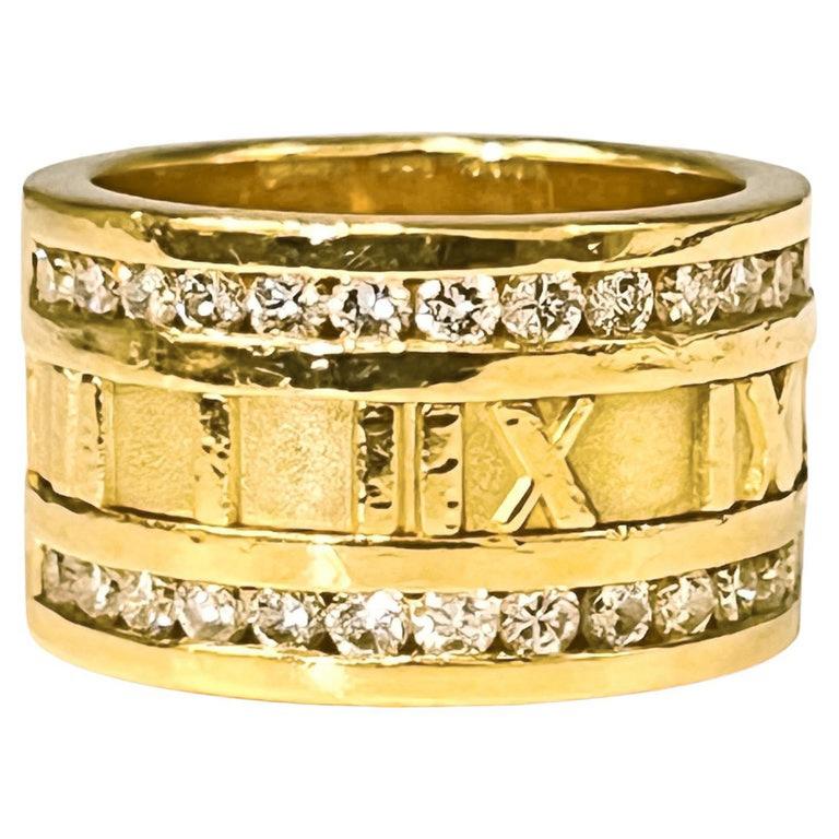 Tiffany & Co 18k Gelbgold breiter Goldring, mit einer zentralen Reihe von römischen Ziffern und eine doppelte Grenze von achtundzwanzig runde Brillanten mit einem Gesamtgewicht von ca. 0,56 Karat (gehen Sie den halben Weg um).  Fingergröße 6 1/4. 