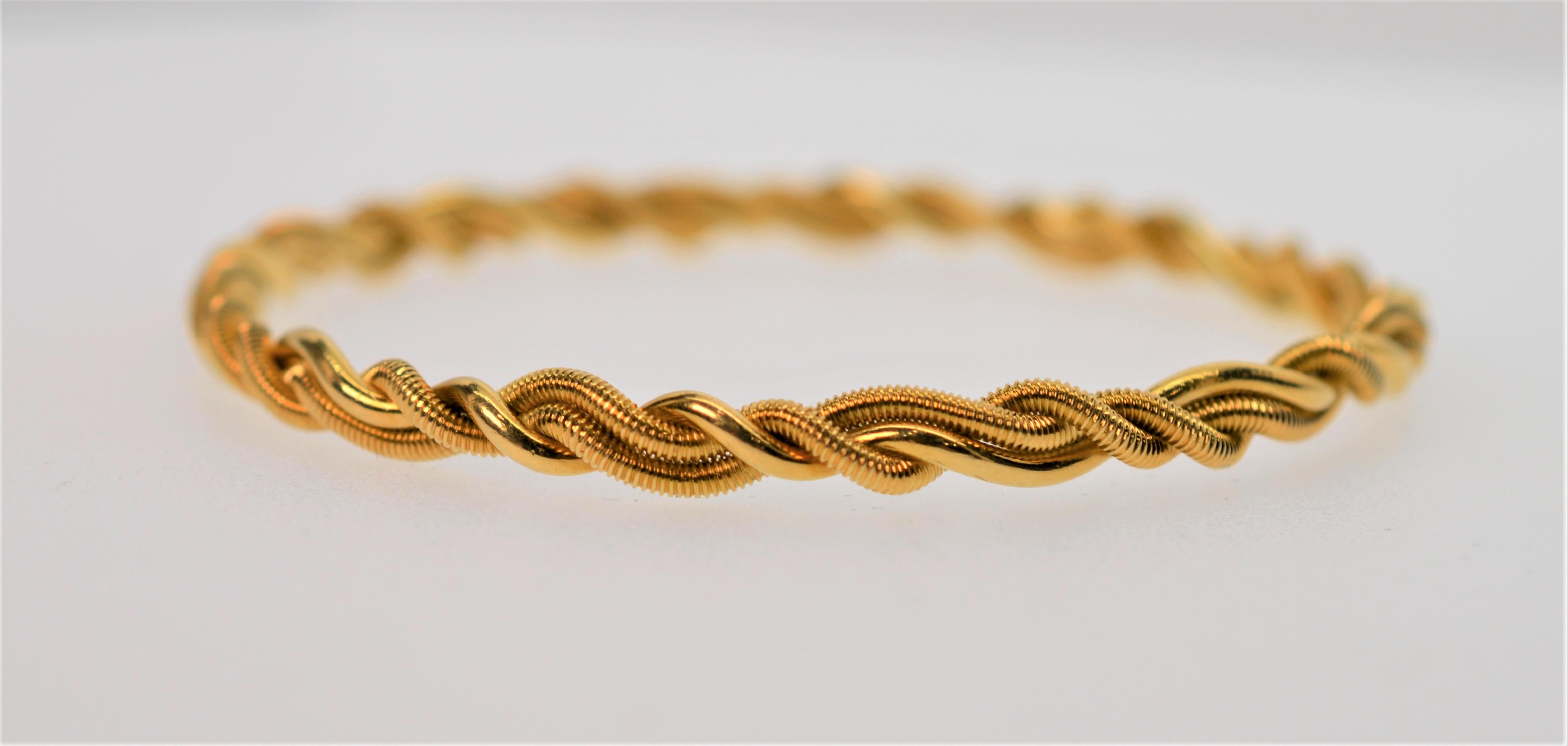 This Tiffany & Co. signed 18K Yellow Gold Bangle Bracelet is expertly crafted with a braided rope design. Versatile and slender design to wear independently or to stack with other pieces in your jewelry wardrobe. Measures 2-3/4 inches in diameter