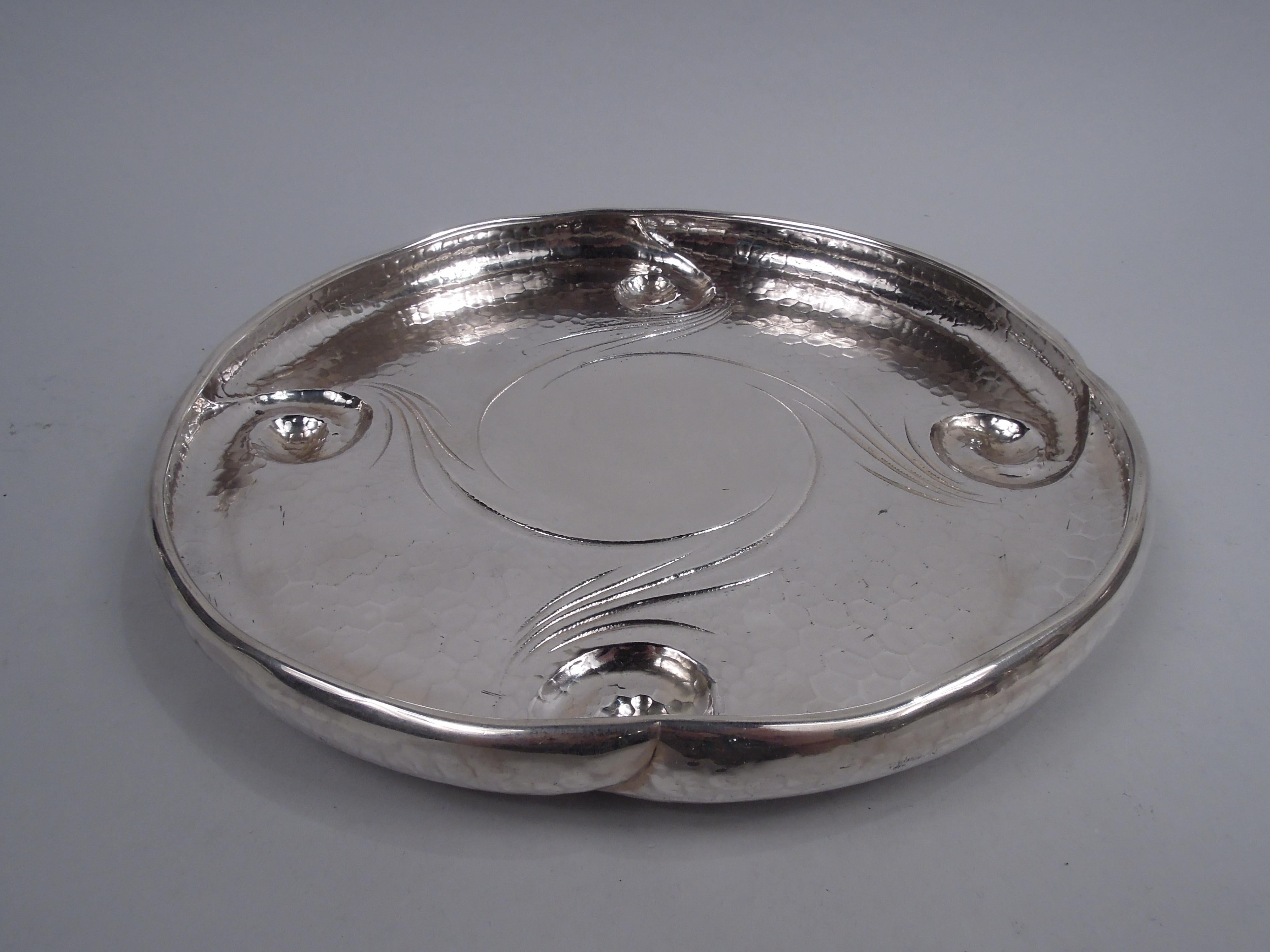 Aesthetic Japonesque sterling silver lily pad tray. Made by Tiffany & Co. in New York, ca 1881. Round with curved and lobed sides. Four “welled” volute scrolls forming supports with stippled tendrils encircling plain center (vacant). Allover spot