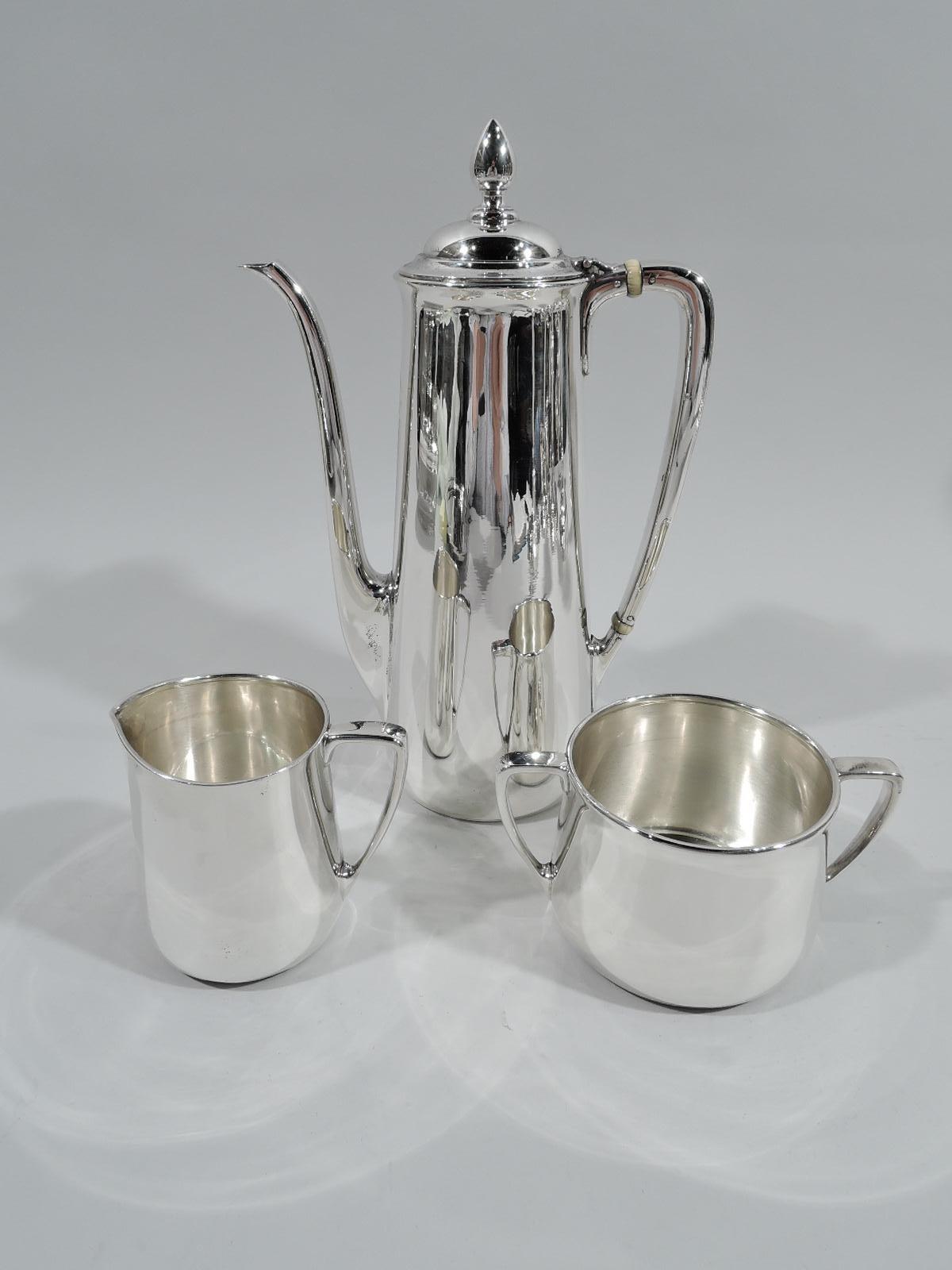 Art Deco sterling silver 3-piece coffee set on tray. Made by Tiffany & Co. in New York, ca 1930. Each: Upward tapering body with gently flared rim. Handles scroll bracket. Coffeepot has hinged and domed cover with ovoid finial and vertical s-scroll