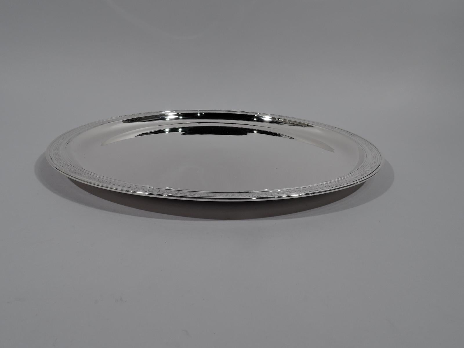 Art Deco sterling silver tray. Made by Tiffany & Co. in New York, circa 1912. Round well with curved sides, flat shoulder acid-etched with stylized chevron leaf band, and molded rim. Fully marked including pattern no. 18316 (first produced in 1912)