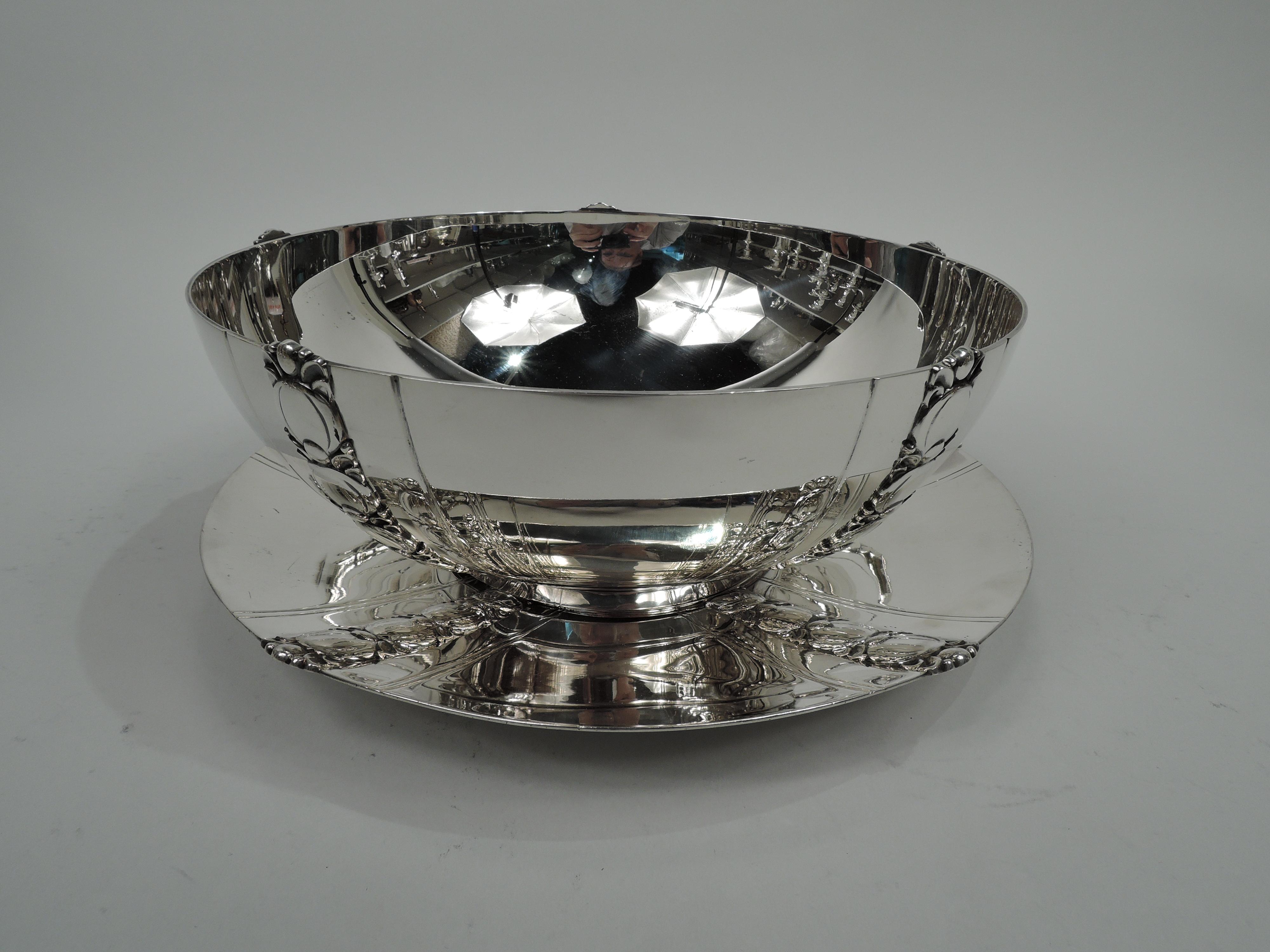 Art Deco sterling silver serving bowl on stand. Made by Tiffany & Co. in New York. Bowl: Curved sides and short and straight foot ring. Vertical pilasters comprising graduated and stylized tomatoes applied to bowl exterior between incised bands.