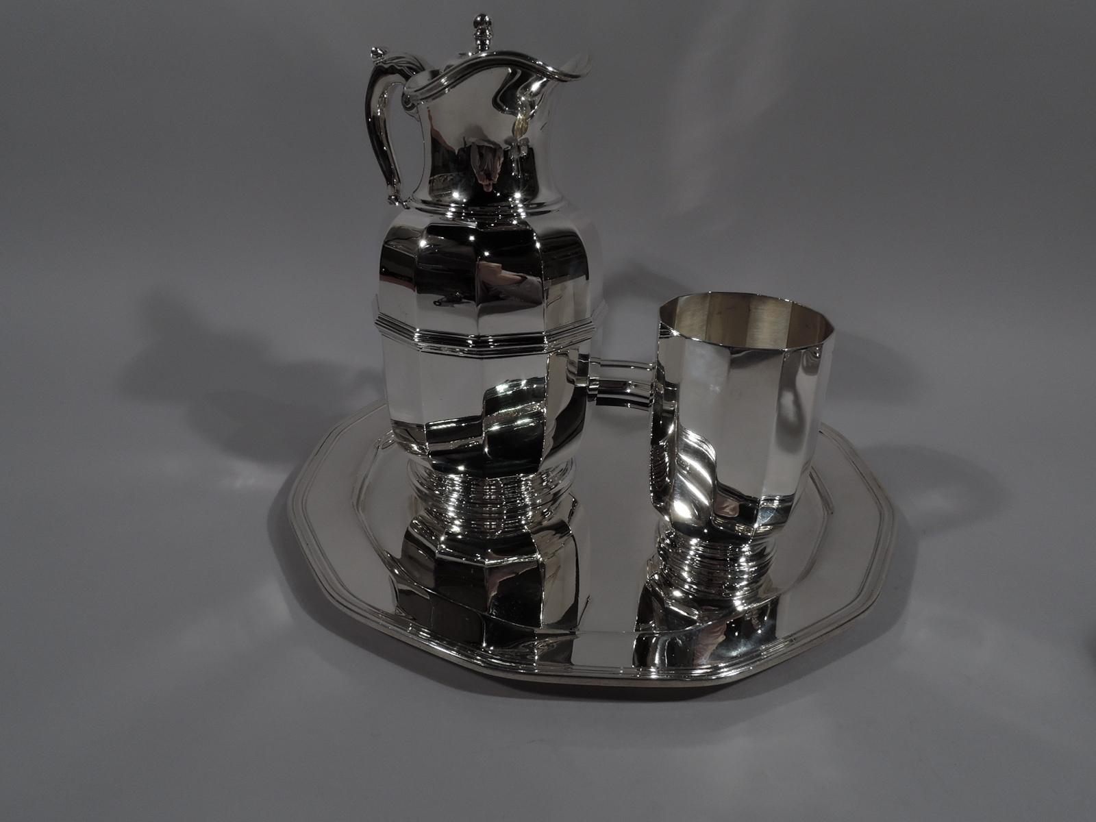 Art Deco sterling silver drinks set for one. Made by Tiffany & Co. in New York, circa 1930. This set comprises carafe, cup, and tray in the faceted geometric style.

Carafe has curved sides with girdle, leaf-capped s-scroll handle, stepped foot.