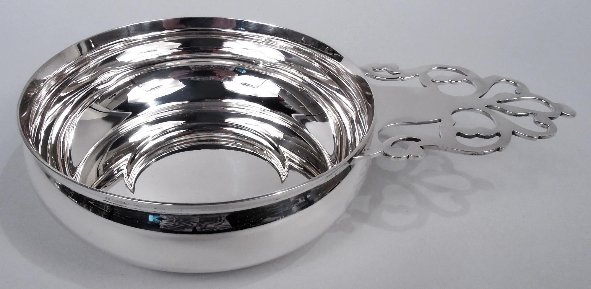 Colonial sterling silver porringer. Made by Tiffany 
Co. in New York. Round and curved bowl with open tree handle. Traditional with room for engraving. Fully marked including maker’s stamp and pattern no. 19206 as well as phrases “Reproduction