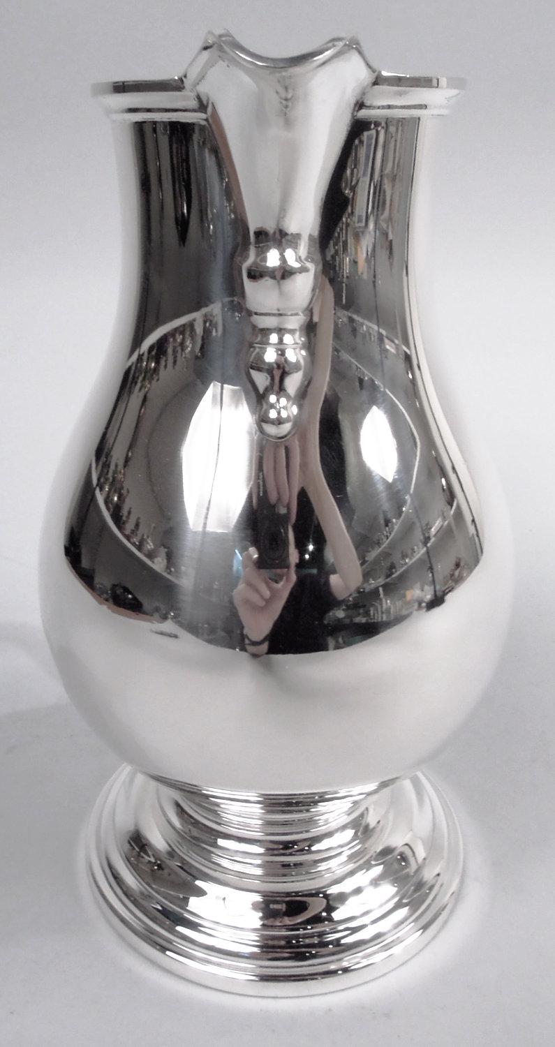 Brocca d'argento in stile coloniale americano, 1920 circa. Venduto da Tiffany & Co. a New York. Corpo a balaustro con manico a voluta e beccuccio a V con ornamento pendente applicato; piede a gradini e rotondo. Contiene 2 3/4 pinte. Marcato 