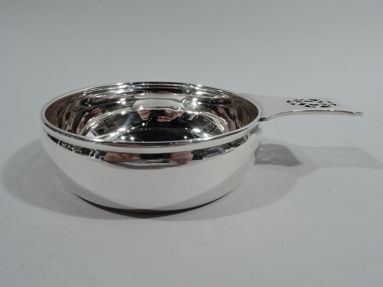 Craftsman sterling silver porringer. Made by Tiffany & Co. in New York, ca 1910. Round bowl with gently curved sides. Solid shaped handle with pierced scrollwork set in open oval. Lots of room for engraving. Fully marked including maker’s stamp,