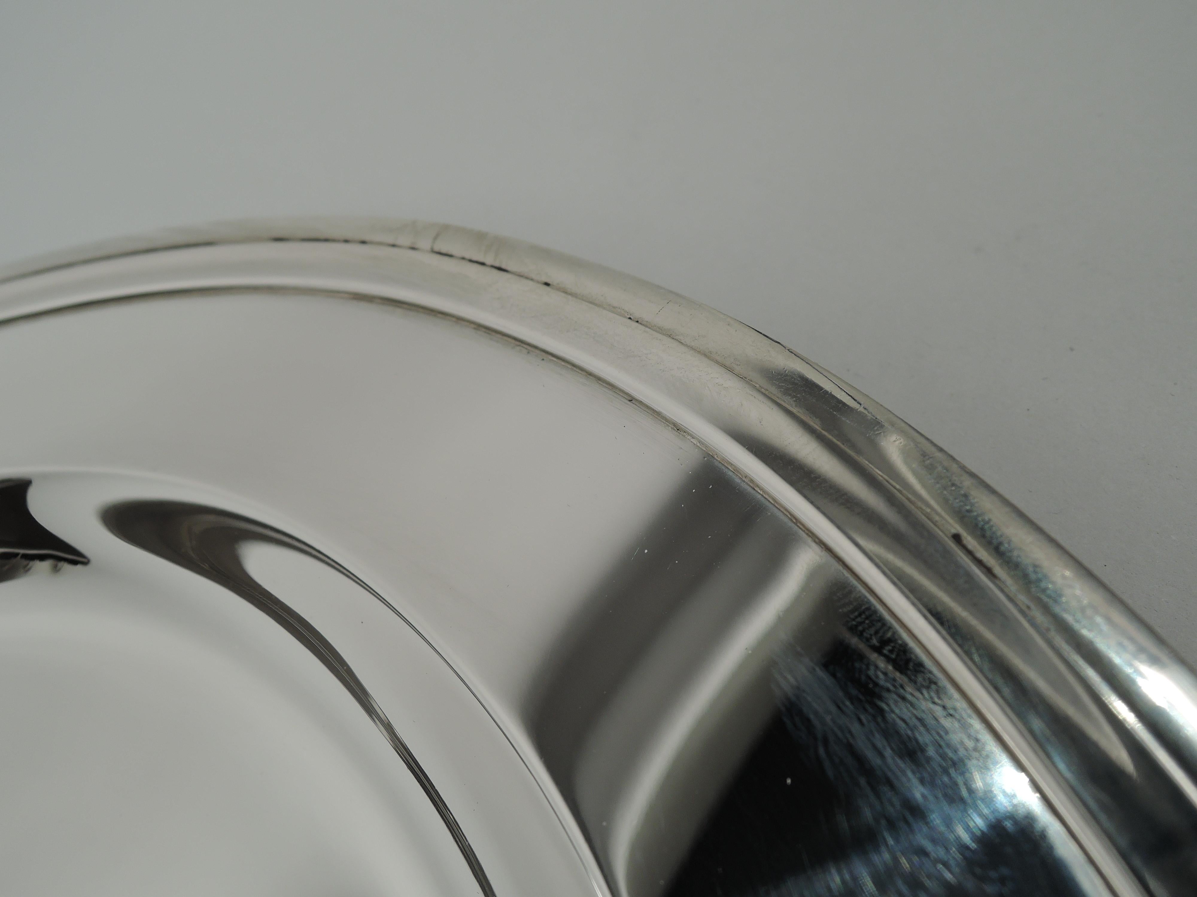 Large and Modern sterling silver serving tray. Made by Tiffany & Co. in New York, ca 1923. Oval with deep well, wide shoulder, and molded rim. Fully marked including maker’s stamp, pattern no. 20182 (first produced in 1923), and director’s letter m.