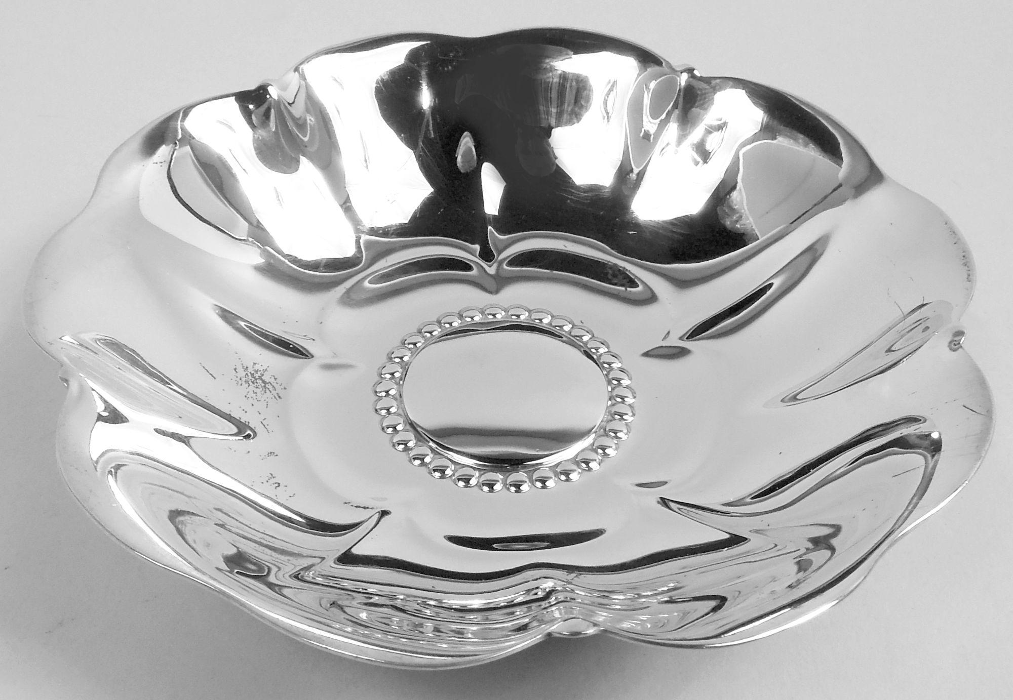 Midcentury Modern sterling silver flowerhead bowl. Made by Tiffany & Co. in New York, ca 1941. Round and curved with scalloped petal rim. Beaded well with chased petal surround. Smart and self-referencing. Fully marked including maker’s stamp,