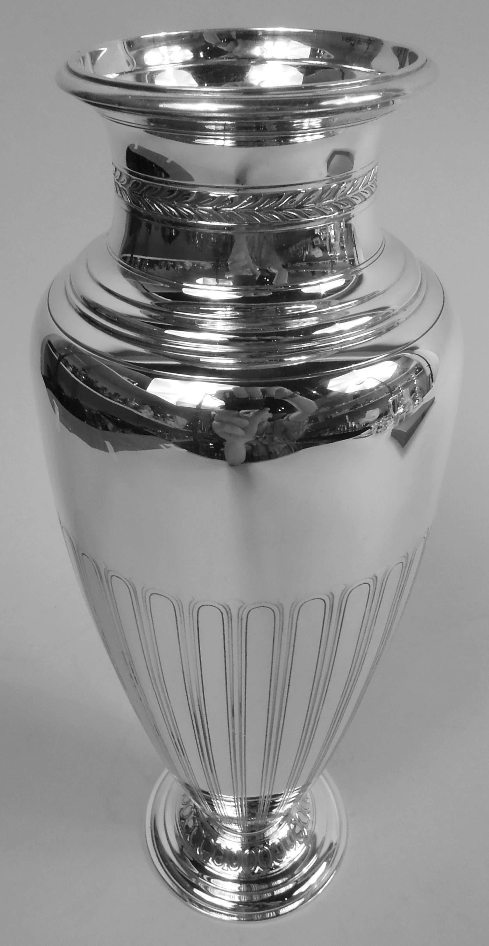 Vase classique moderne en argent sterling. Fabriqué par Tiffany & Co. à New York, ca. 1913. Corps ovoïde avec un col court et un pied surélevé. Ornement stylisé gravé et dégagé à l'acide : Bordure de feuilles imbriquées sur le col et bordure en