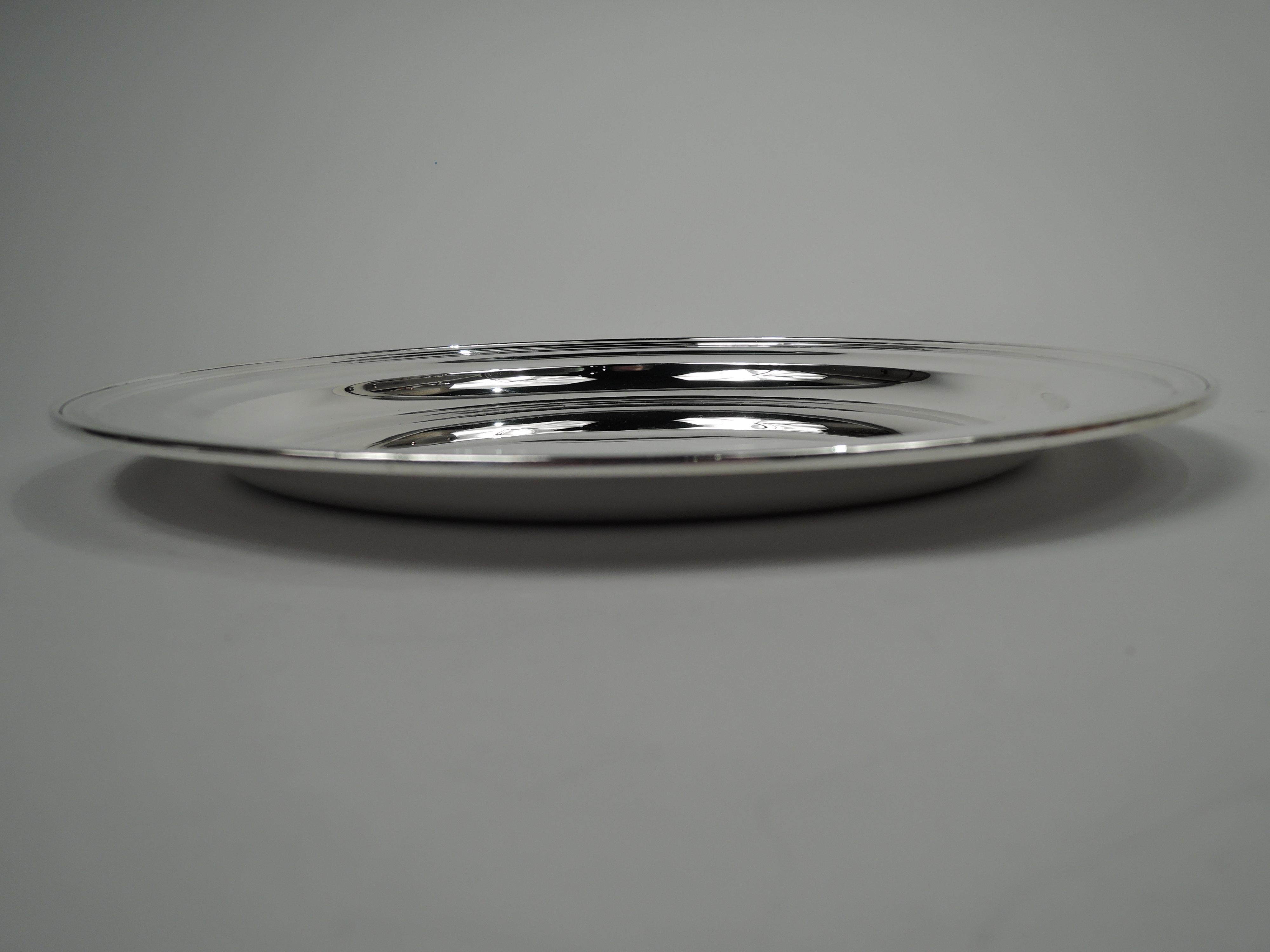 Modern sterling silver tray. Made by Tiffany & Co. in New York, ca 1910. Round with deep well, narrow shoulder, and reeded rim. Fully marked including maker’s stamp, pattern no. 11742C, and director’s letter m. Heavy weight: 32 troy ounces. 