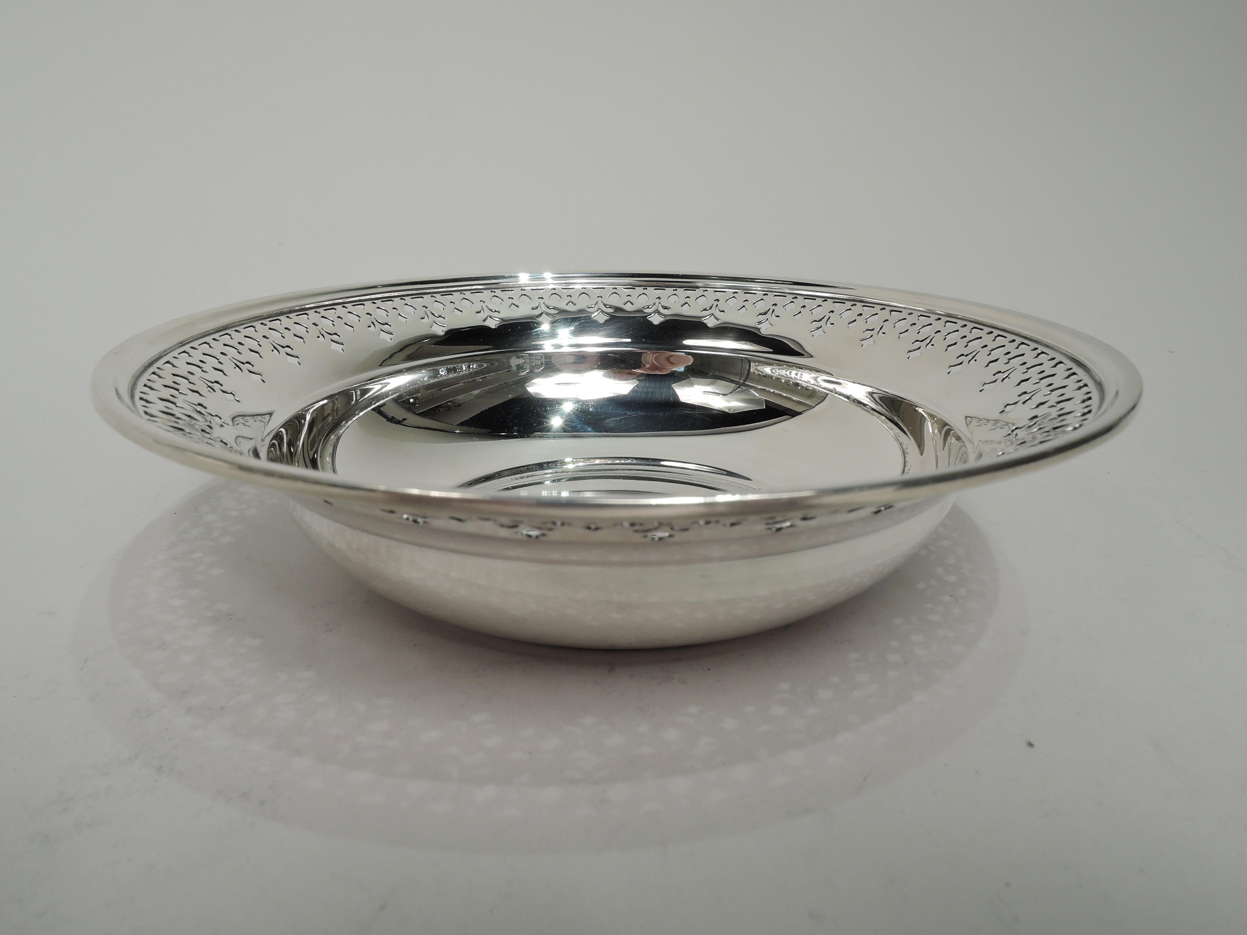 Modern sterling silver bowl. Made by Tiffany & Co. in New York. Solid and curved well and wide and tapering shoulder with pierced ornament. Fully marked including maker’s stamp, pattern no. 20675K (first produced in 1926), and director’s letter m.