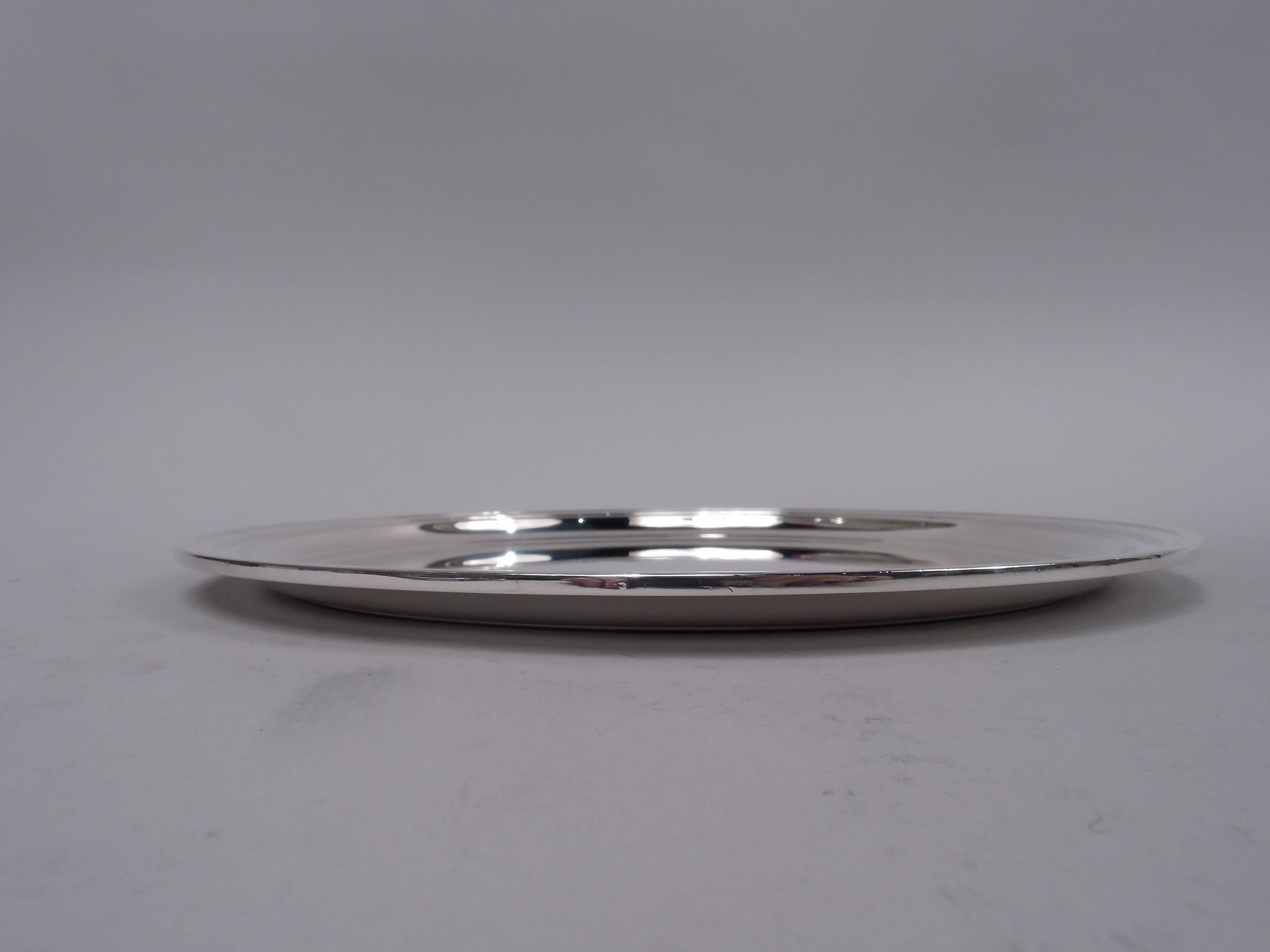 Modern sterling silver serving tray. Made by Tiffany & Co. in New York. Round with stepped rim. Smart and functional. Nice heft. Fully marked including maker’s stamp, pattern no. 21252, and director’s letter M (1947-56). Weight: 14.7 troy ounces. 