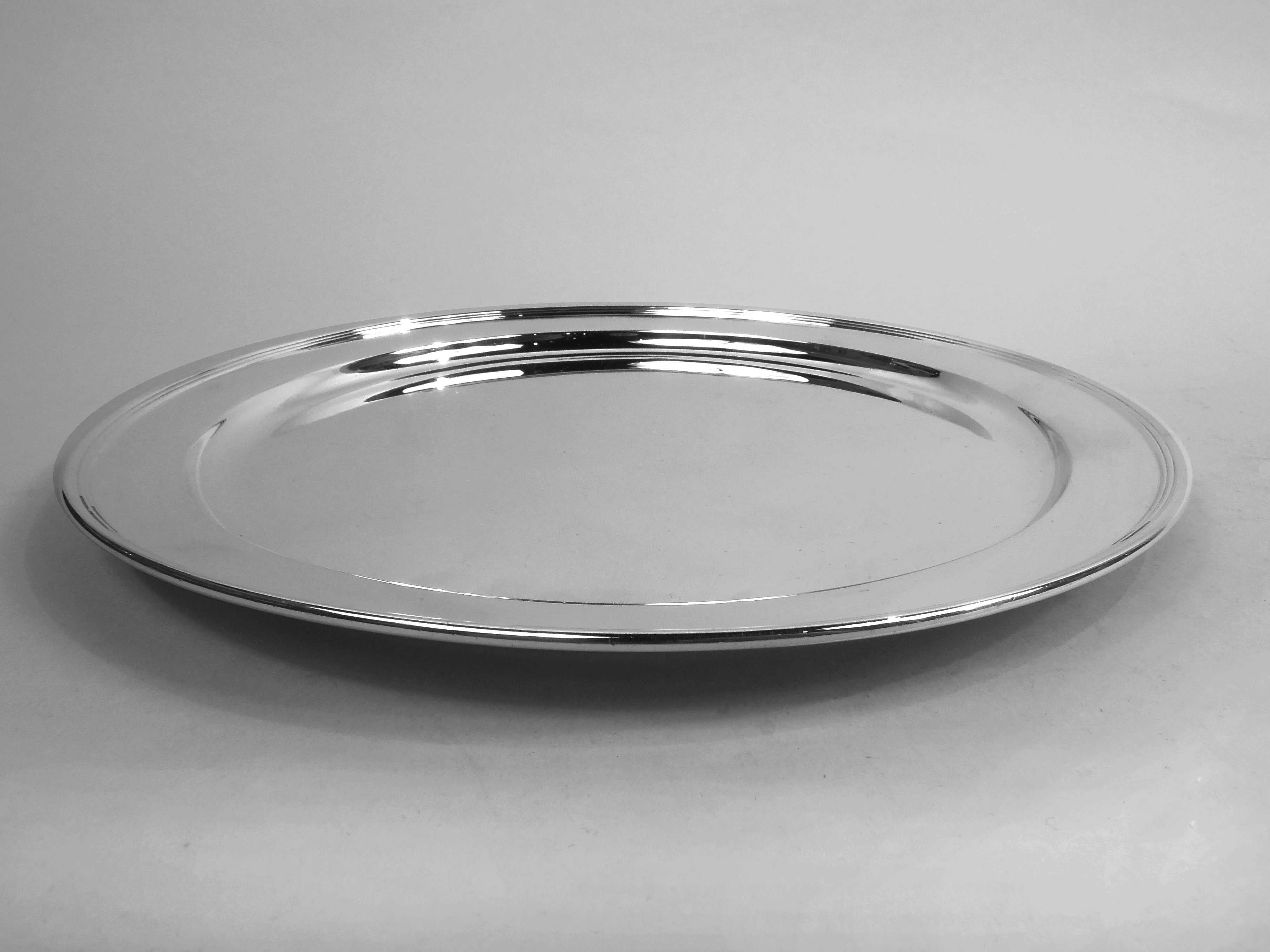 Modern sterling silver tray. Made by Tiffany & Co. in New York, ca 1915. Round with tapering shoulder and reeded rim. Fully marked including maker’s stamp, pattern no. 18975 (first produced in 1915), and director’s letter m. Weight: 18.8 troy