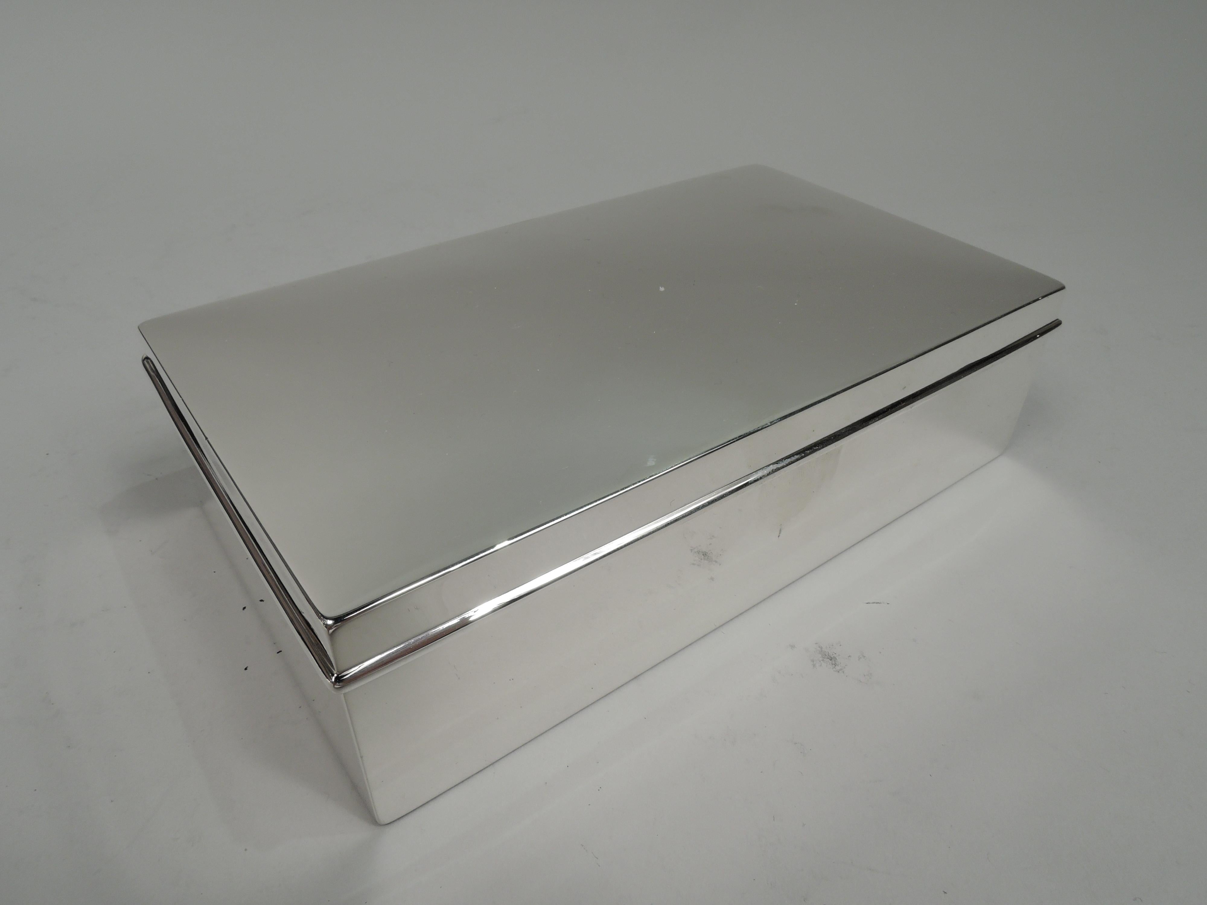 Modern sterling silver box. Made by Tiffany & Co. in New York, ca 1919. Rectangular with straight sides. Cover hinged with gently curved top and overhanging rim. Box interior cedar lined. Cover interior gilt washed. Fully marked including maker’s
