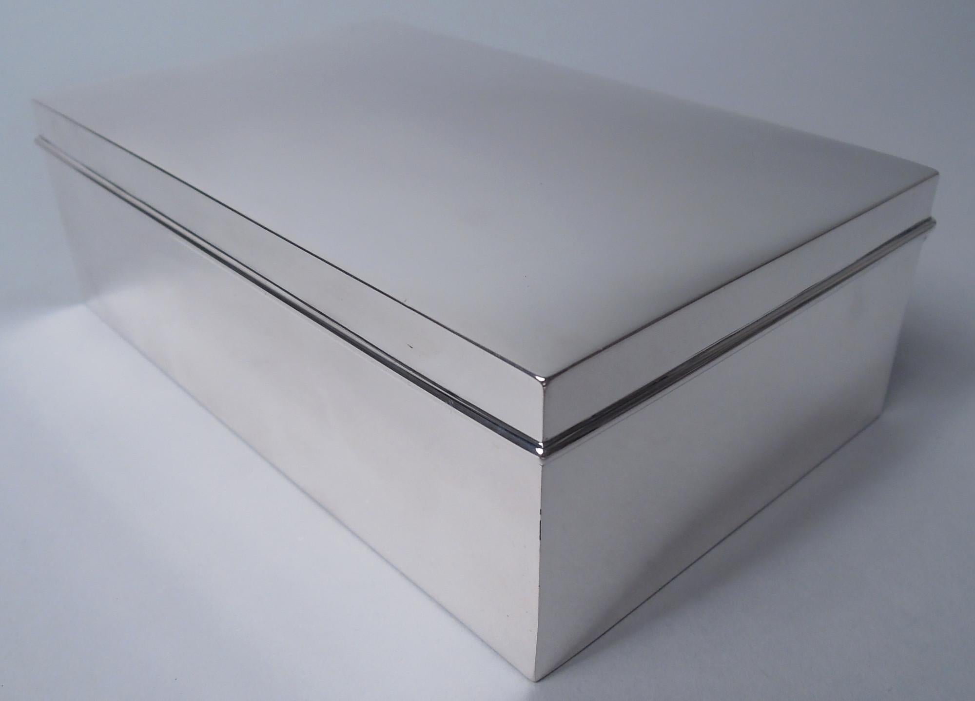 Boîte moderne en argent sterling. Fabriqué par Tiffany & Co. à New York, ca. 1912. Rectangulaire avec des côtés droits. Couvercle à charnière avec dessus légèrement incurvé et bord moulé. L'intérieur de la boîte est doublé de cèdre. Entièrement