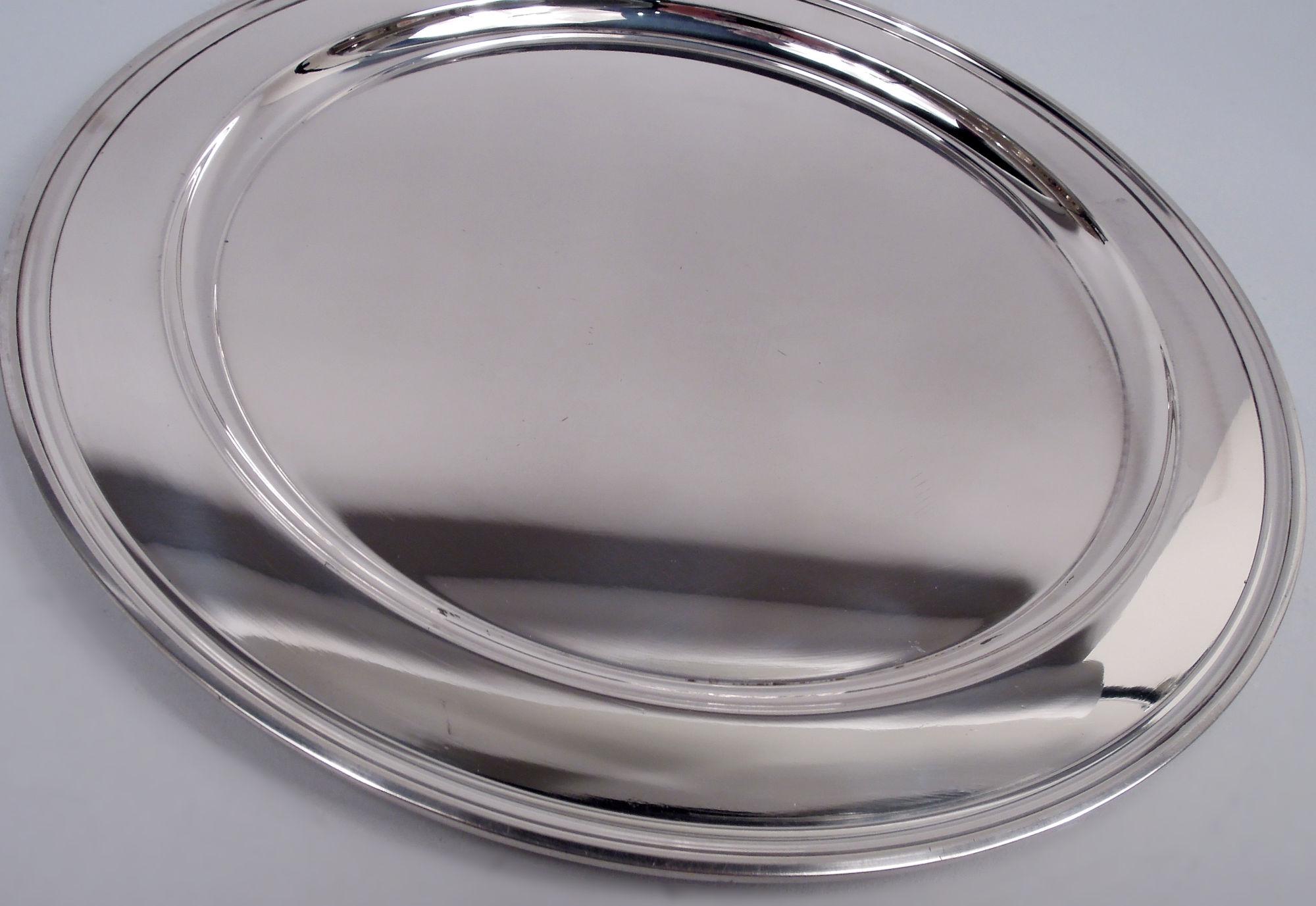 Plateau moderne en argent sterling. Fabriqué par Tiffany & Co. à New York, ca. 1923. Puits profond, épaule large et bord moulé. Entièrement marquée avec le cachet du fabricant et le numéro de modèle 20219 (première production en 1923). Poids : 23