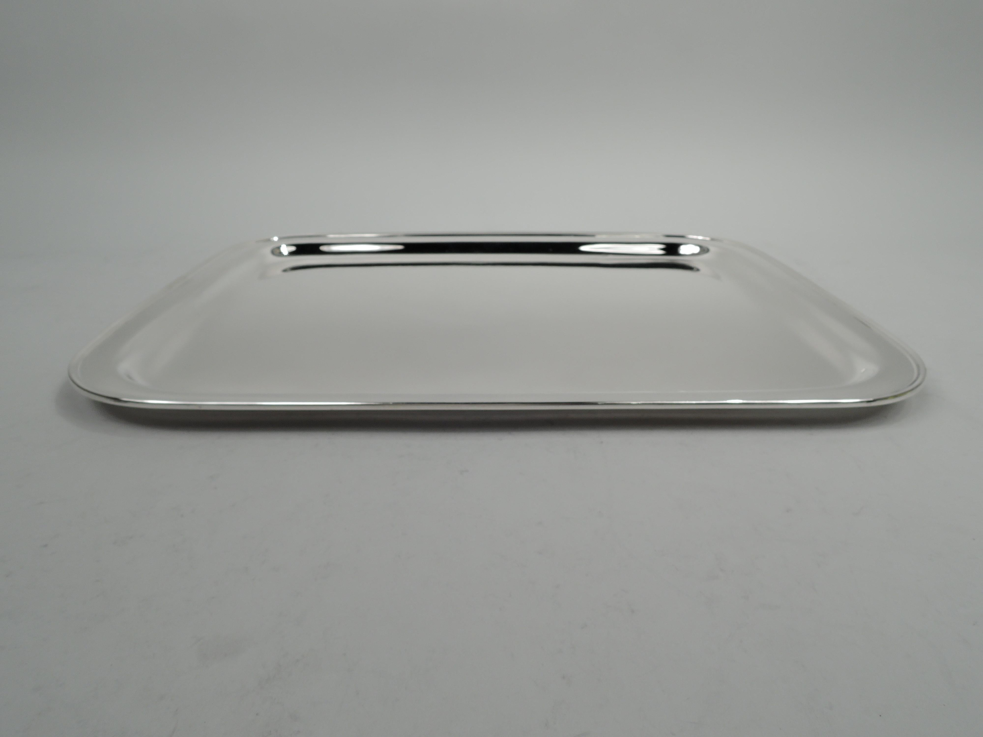 Modern sterling silver serving tray. Made by Tiffany & Co. in New York, circa 1937. Rectangular well with curved corners, flat shoulder, and molded rim. Fully marked including maker’s stamp, pattern no. 22552 (first produced in 1937), and director’s