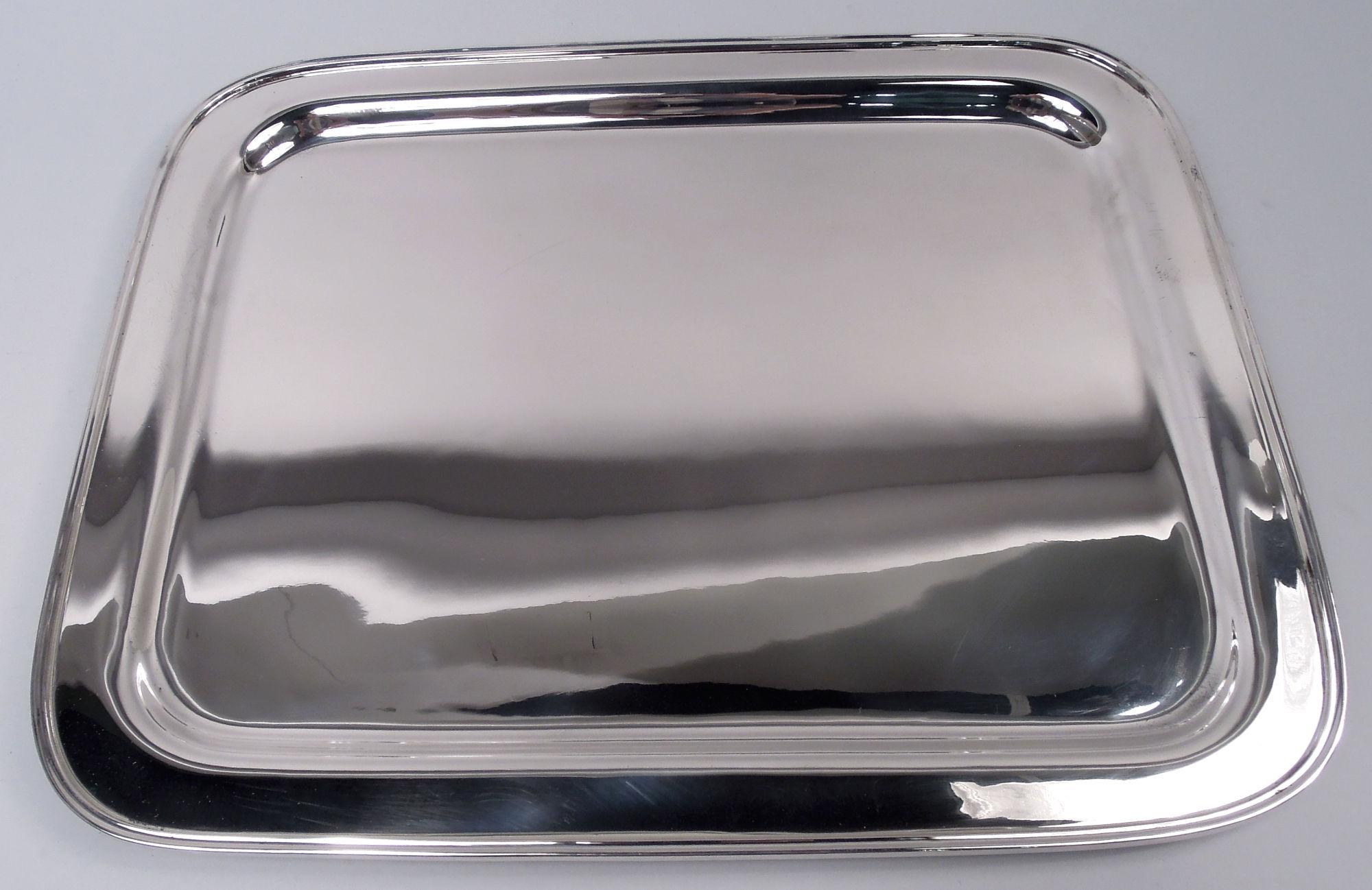 Bandeja moderna de plata de ley para servir. Fabricado por Tiffany & Co. en Nueva York, hacia 1960. Pozo rectangular con esquinas curvadas, hombro plano y estrecho, y borde moldeado. Completamente marcada incluyendo el sello del fabricante y el