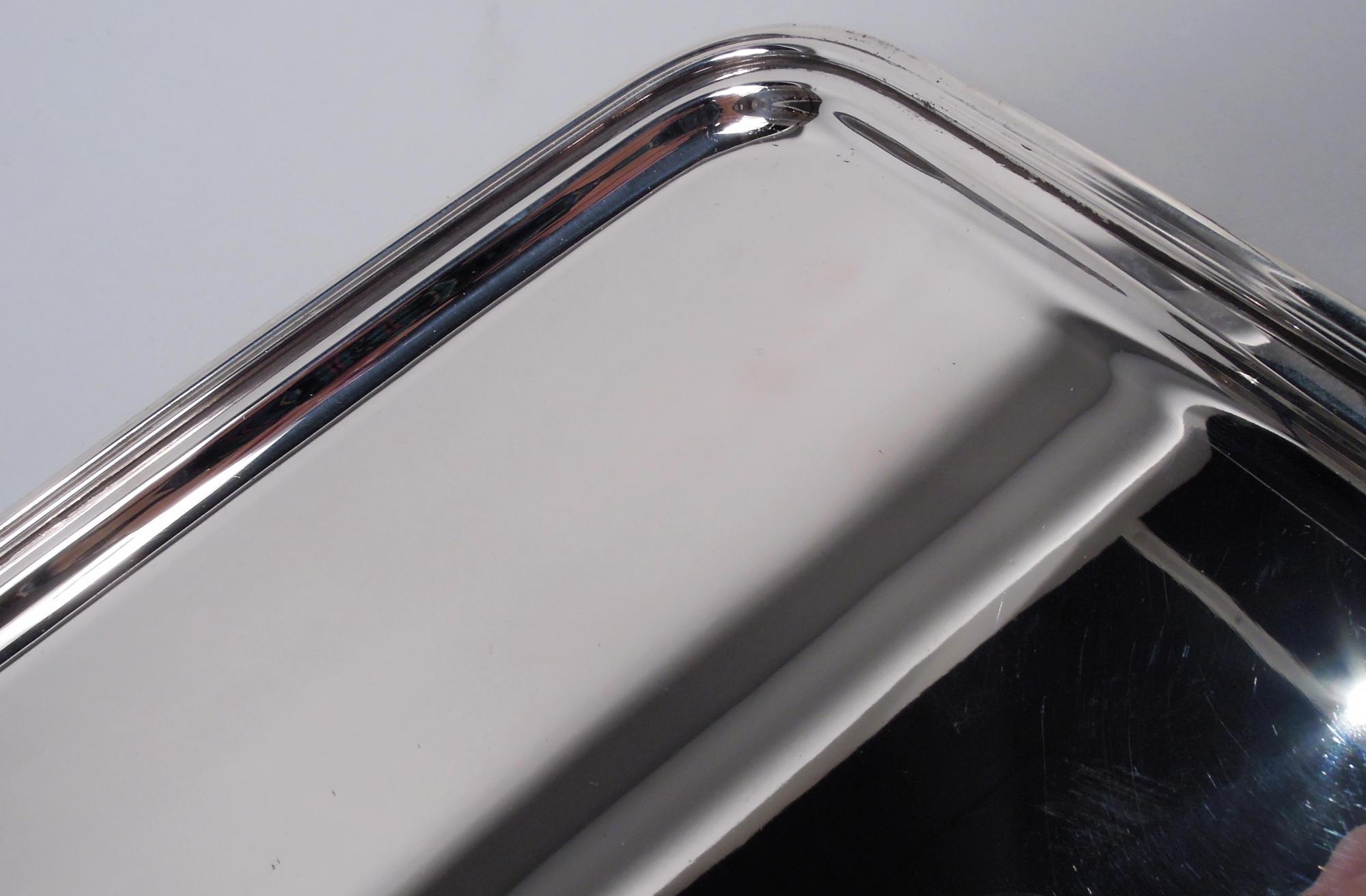 Modern sterling silver tray. Made by Tiffany & Co. in New York, ca 1960. Rectangular well with curved corners, flat and narrow shoulder, and reeded rim. Fully marked including maker’s stamp and pattern no. 20151. Weight: 23.8 troy ounces. 