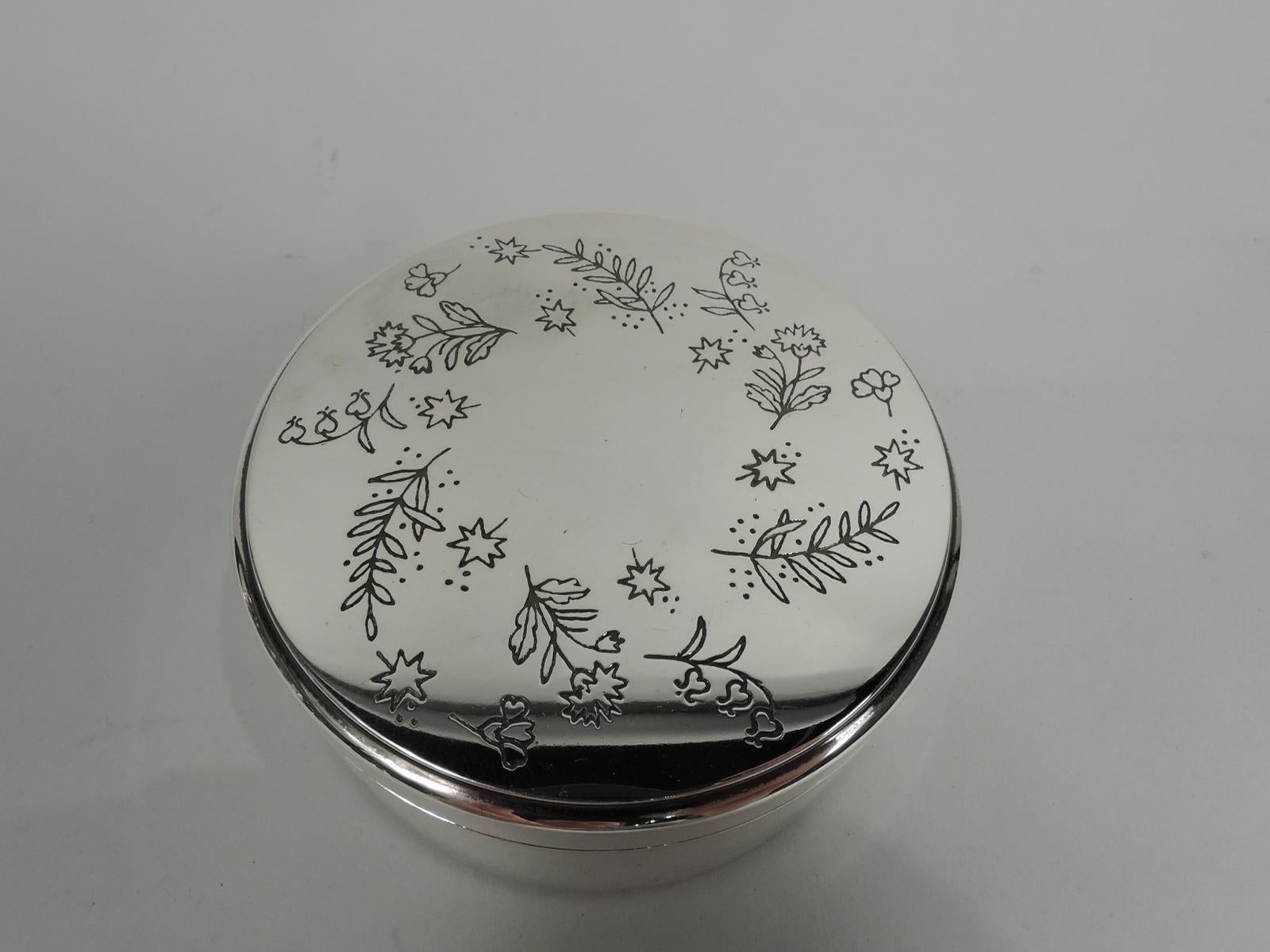 Modern sterling silver trinket box. Made by Tiffany & Co. in New York. Round with straight sides. Cover top flat and engraved with scattered flowers and foliage. Gilt washed-interior. Smart and handy. Fully marked including maker’s stamp, pattern