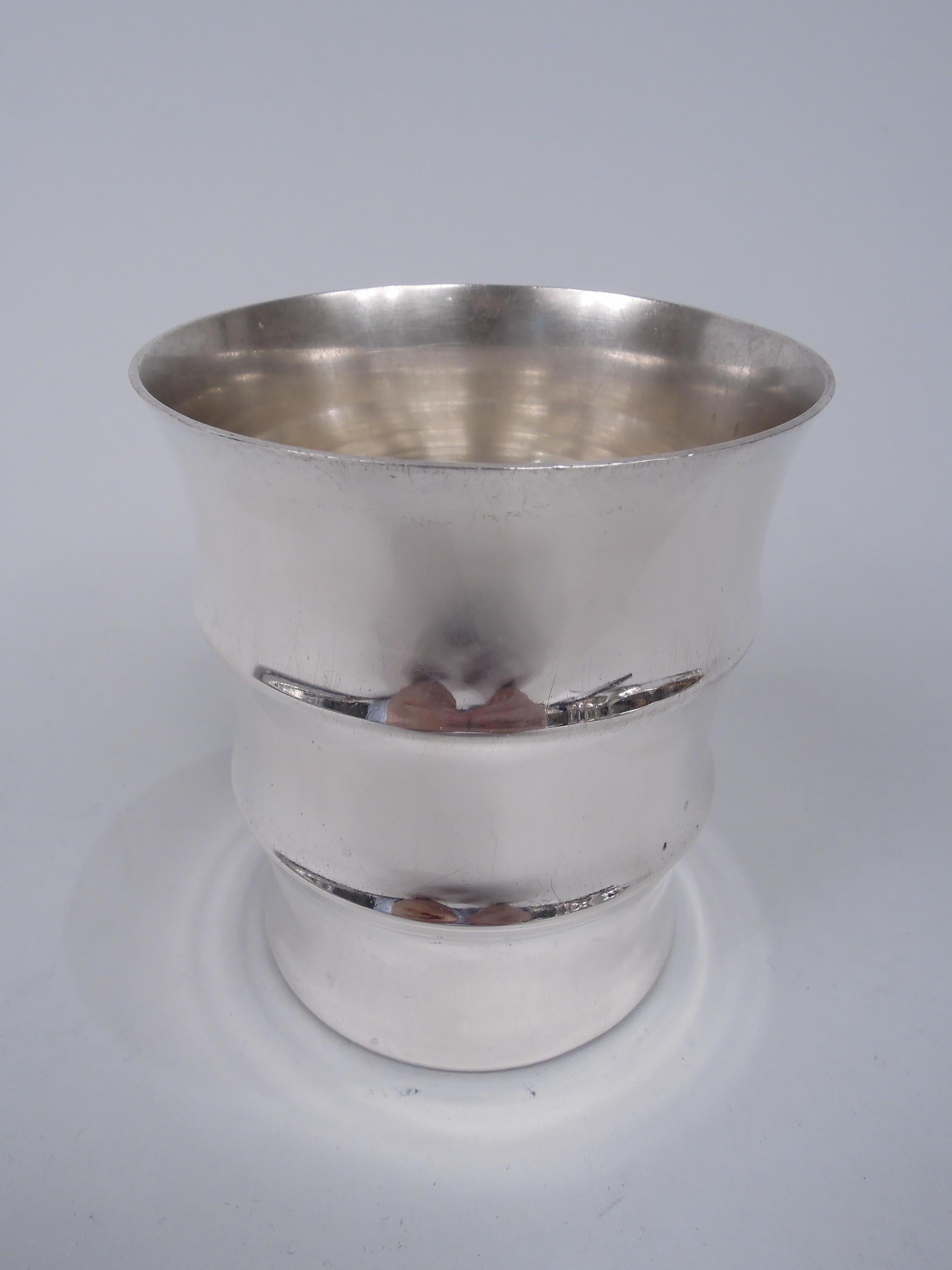 American Modern sterling silver tumbler. Sides comprise three concave rings with flared mouth rim. Marked “Tiffany & Co / Sterling / 549”. Weight: 4.6 troy ounces.