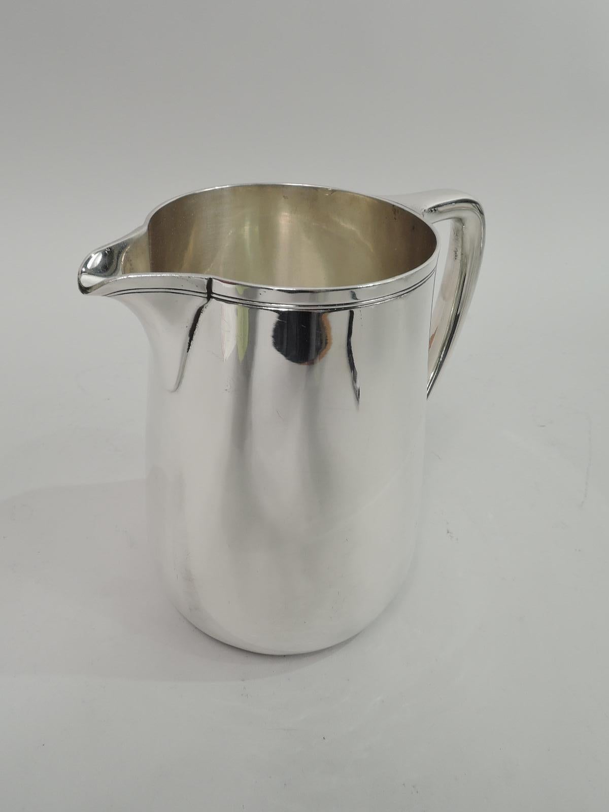 Modern sterling silver water pitcher. Made by Tiffany & Co. in New York. Upward tapering sides, scrolled bracket handle, and v-spout. Spare incised banding near rim. Holds 3 1/2 pints. Fully marked including maker’s stamp, pattern no. 22343,