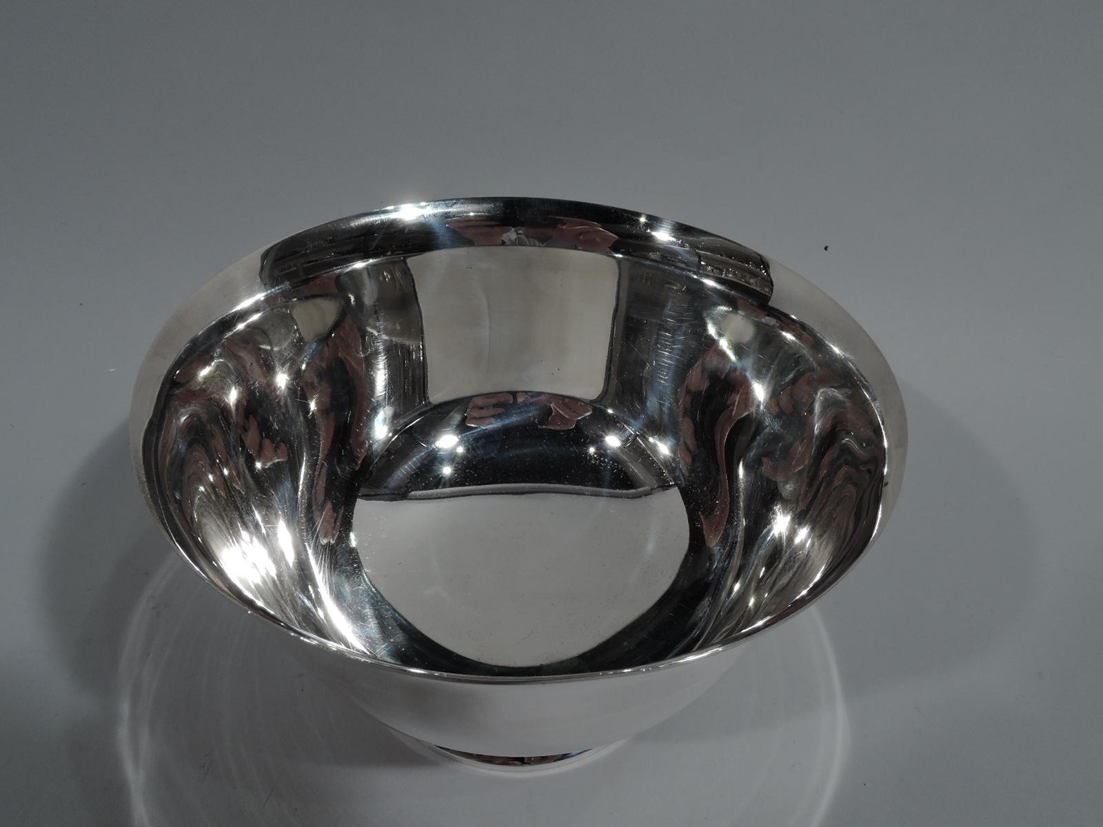 Sterling silver Revere bowl. Made by Tiffany & Co. in New York. Curved sides, flared rim, and stepped foot. A nice small version of a traditional form. Hallmark includes postwar pattern no. 23615 and director’s letter L (circa 1956-1965). Weight: