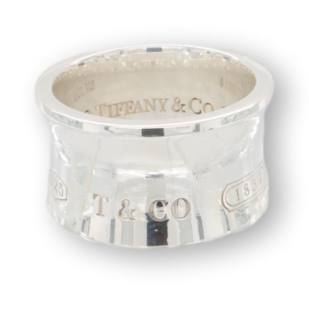 Tiffany & Co. wide band ring from the 1837 collection finely crafted in sterling silver measuring 12 mm wide with a contour design. Fully hallmarked with Tiffany logos and metal content.

Ring Specifications
Brand: Tiffany & Co. 
Style: 1837
