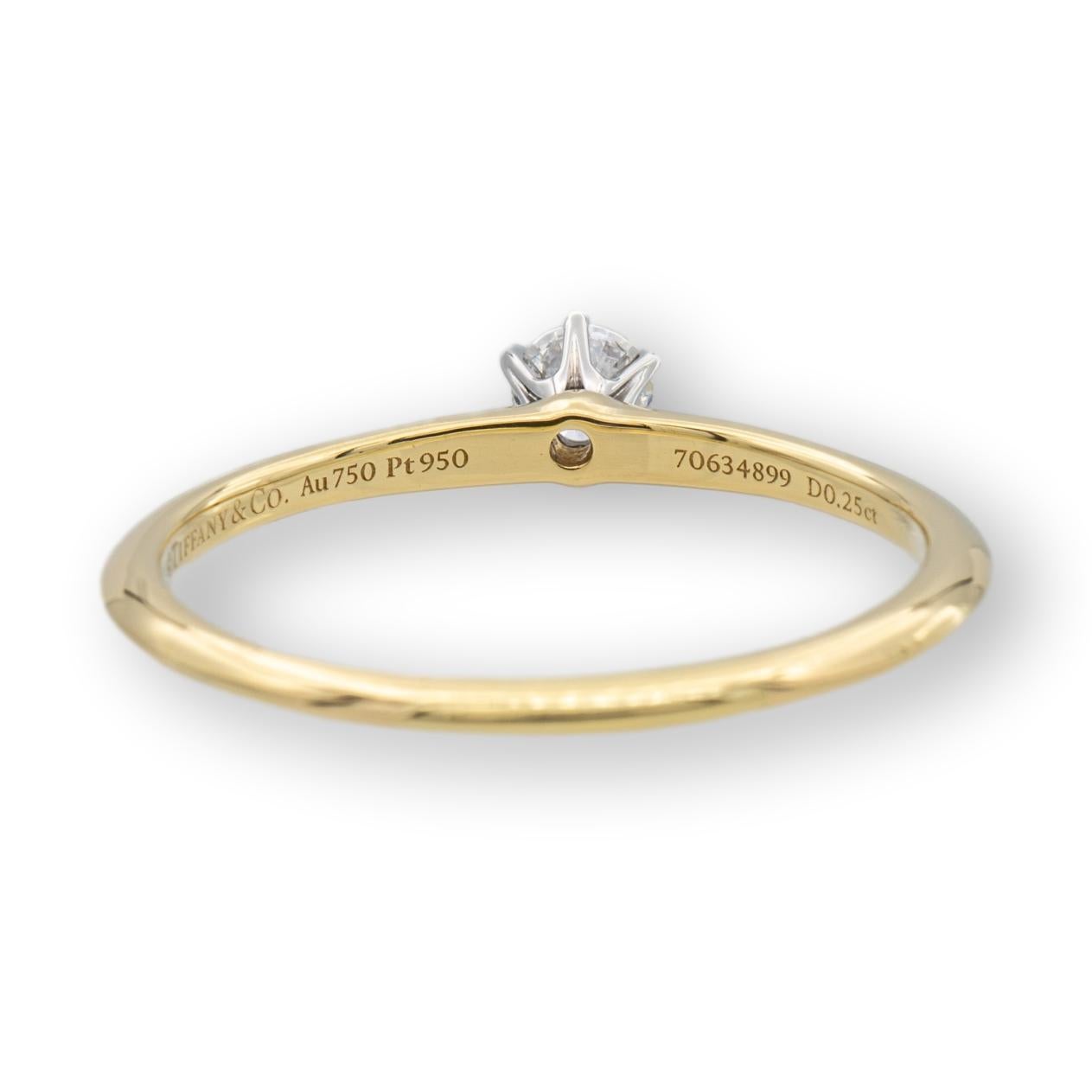 Tiffany & Co. classic solitaire engagement ring finely crafted in 18 karat yellow gold featuring a round brilliant diamond center weighing .25 cts  F color , Fine VVS2 clarity set in a platinum 6 prong basket setting. Diamond is considered triple X