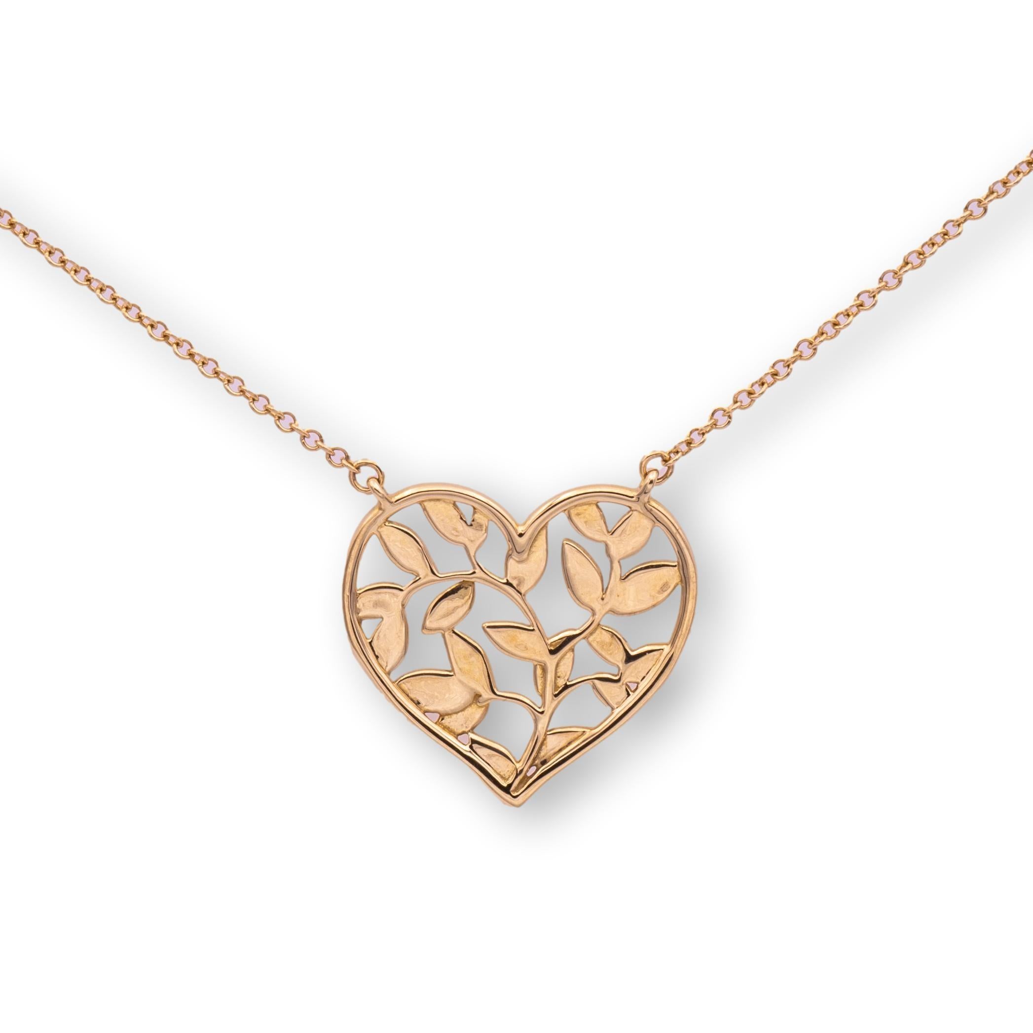 Tiffany and Co. Olive leaf heart pendant necklace designed by Paloma Picasso finely crafted in 18 karat yellow gold hanging off an 18