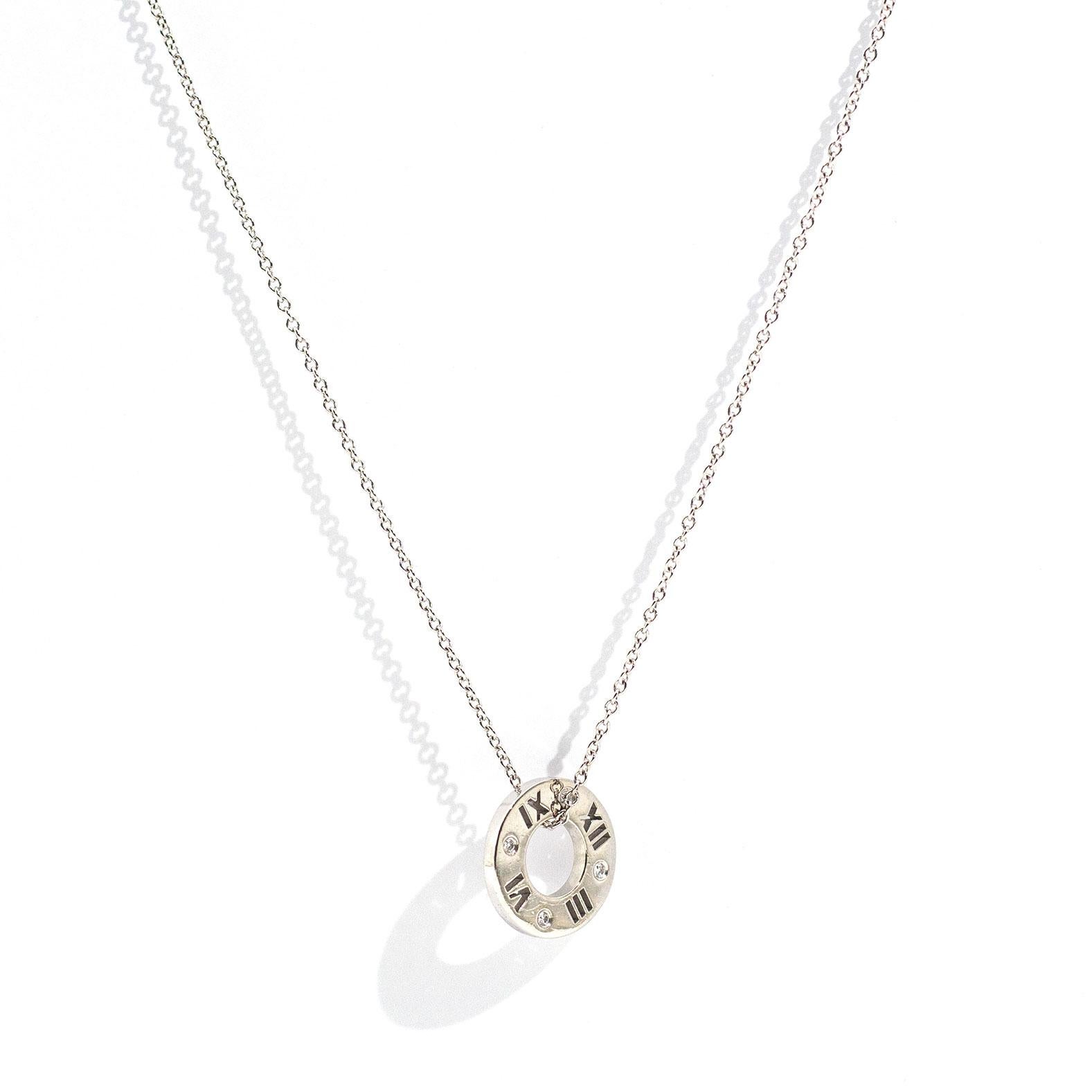 18 carat white gold Tiffany and Co Atlas Pierced Pendant threaded on a Tiffany Co 18 carat white gold chain features four hammer set round brilliant cut diamonds positioned around the pendant on one side. The Tiffany and Co Atlas Pierced Pendant and