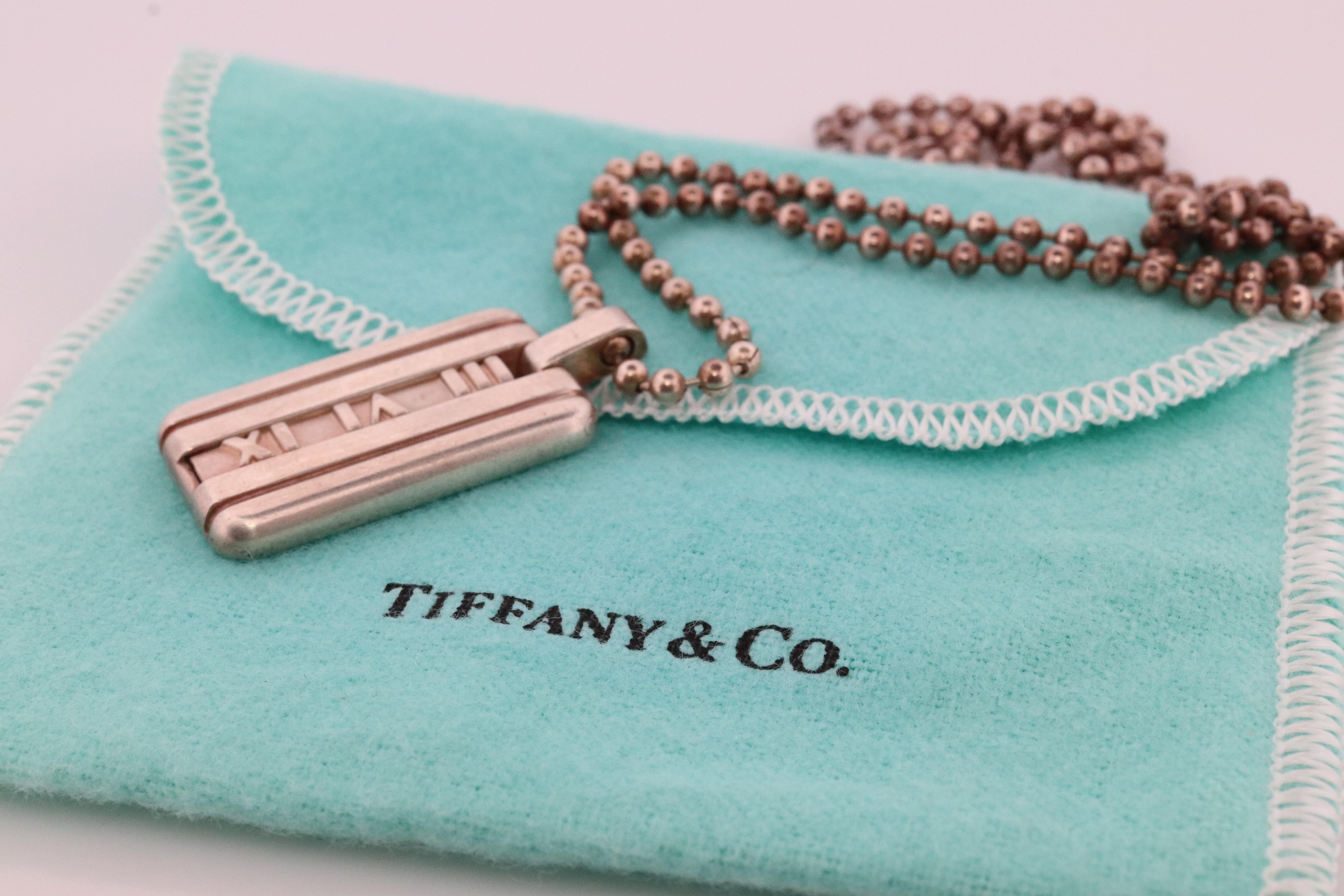 Genuine Tiffany and Co.  Pendant

Atlas Dogtag with Necklace

925 Sterling Silver.

Minor signs of wear. 
Comes with Tiffany Co Pouch.


16mm by 27mm pendant
20in sterling silver chain necklace
