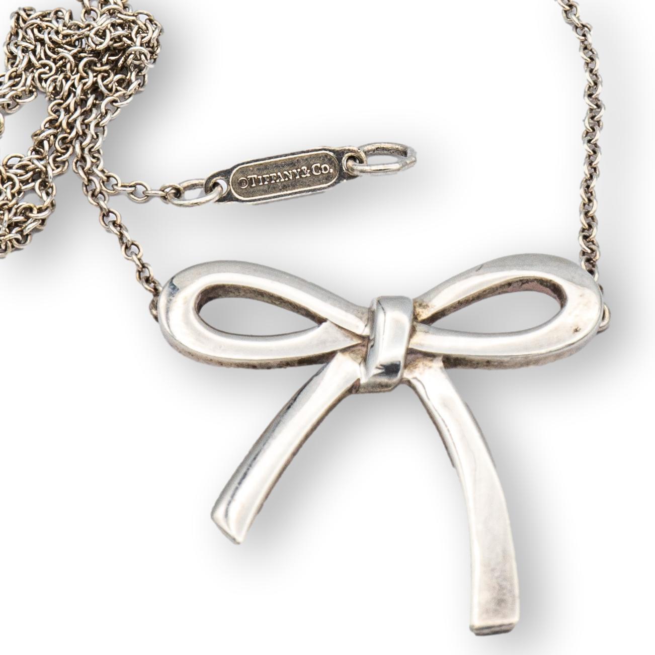 Tiffany & Co. bow necklace finely crafted in sterling silver with link necklace and spring ring closure clasp. The bow pendant is stationary and measures 0.75