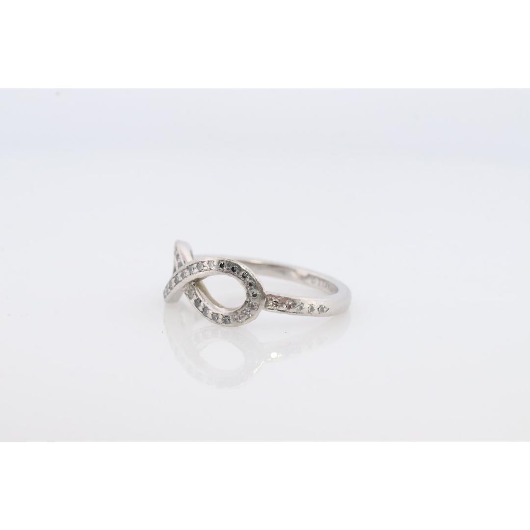 Vintage from the 1990s
Size: 4 1/2 US
Materials: Platinum
Gemstone: Diamond
Gem color: Colorless

Band color: Silver

Rare Tiffany and Co. Platinum Diamond Ring.

Hallmarked Tiffany & Co. PT950. Tests appropriately.

Infinity Loop encrusted with