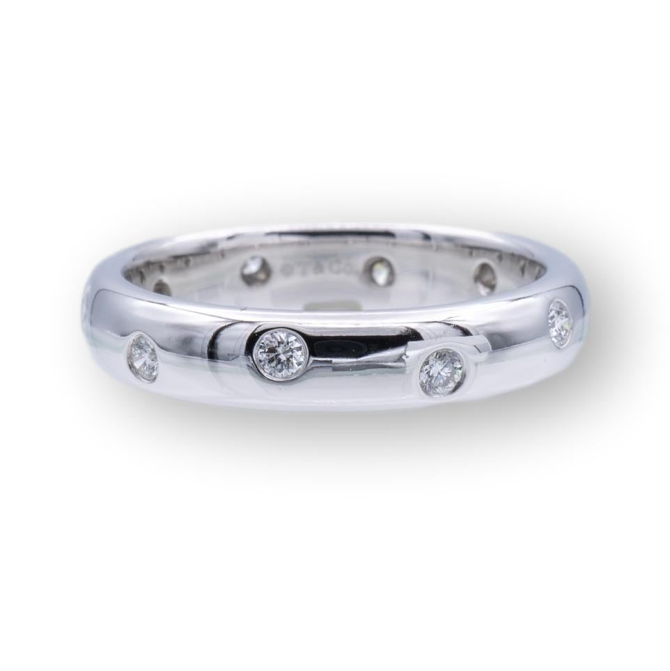Tiffany & Co. Etoile Domed Band Ring finely crafted in Platinum measuring 4mm wide with 10 round brilliant cut diamonds set in platinum bezels weighing 0.22 carats total weight approximately. The band is domed and comfort fit.

RING