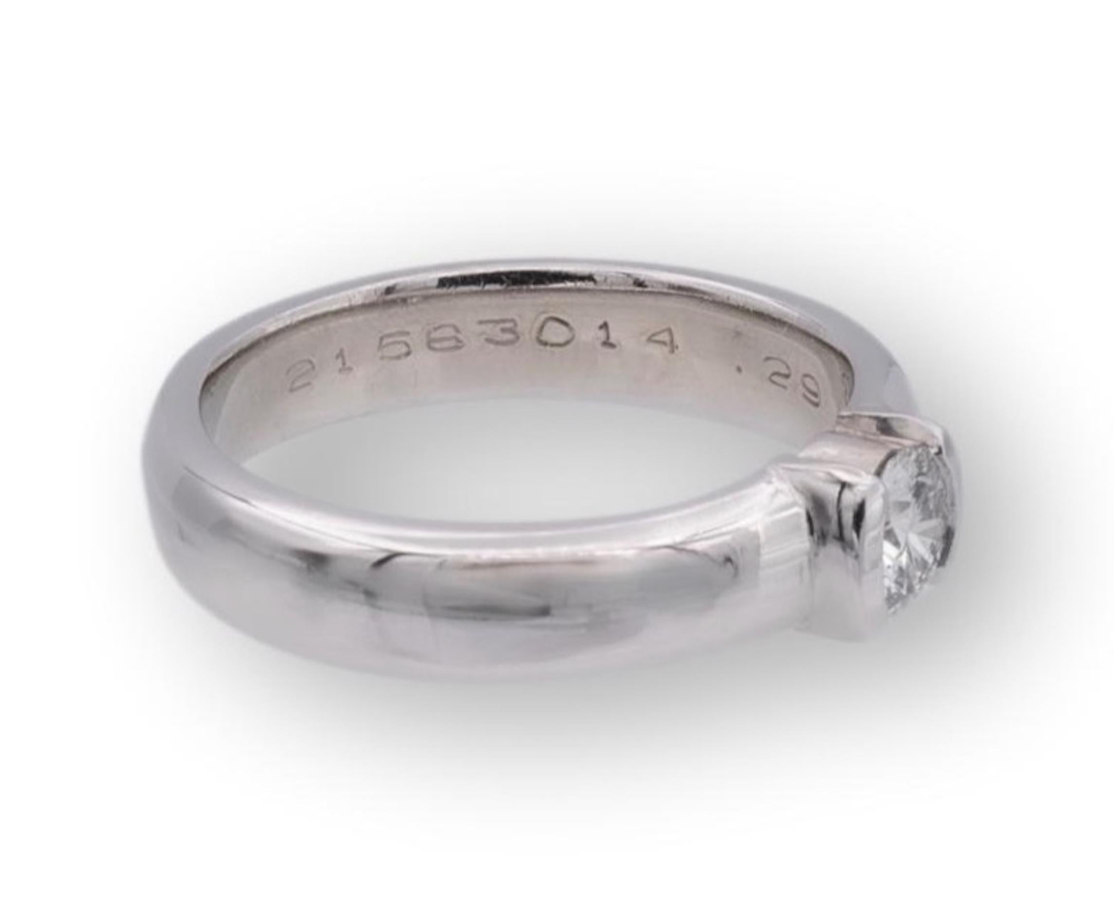 Tiffany and Co. engagement ring from the Etoile collection finely crafted in platinum featuring a round brilliant cut diamond center weighing 0.29 cts. G-H color , VVS1-VVS2 clarity set in a half bezel setting. The original Tiffany certificate for