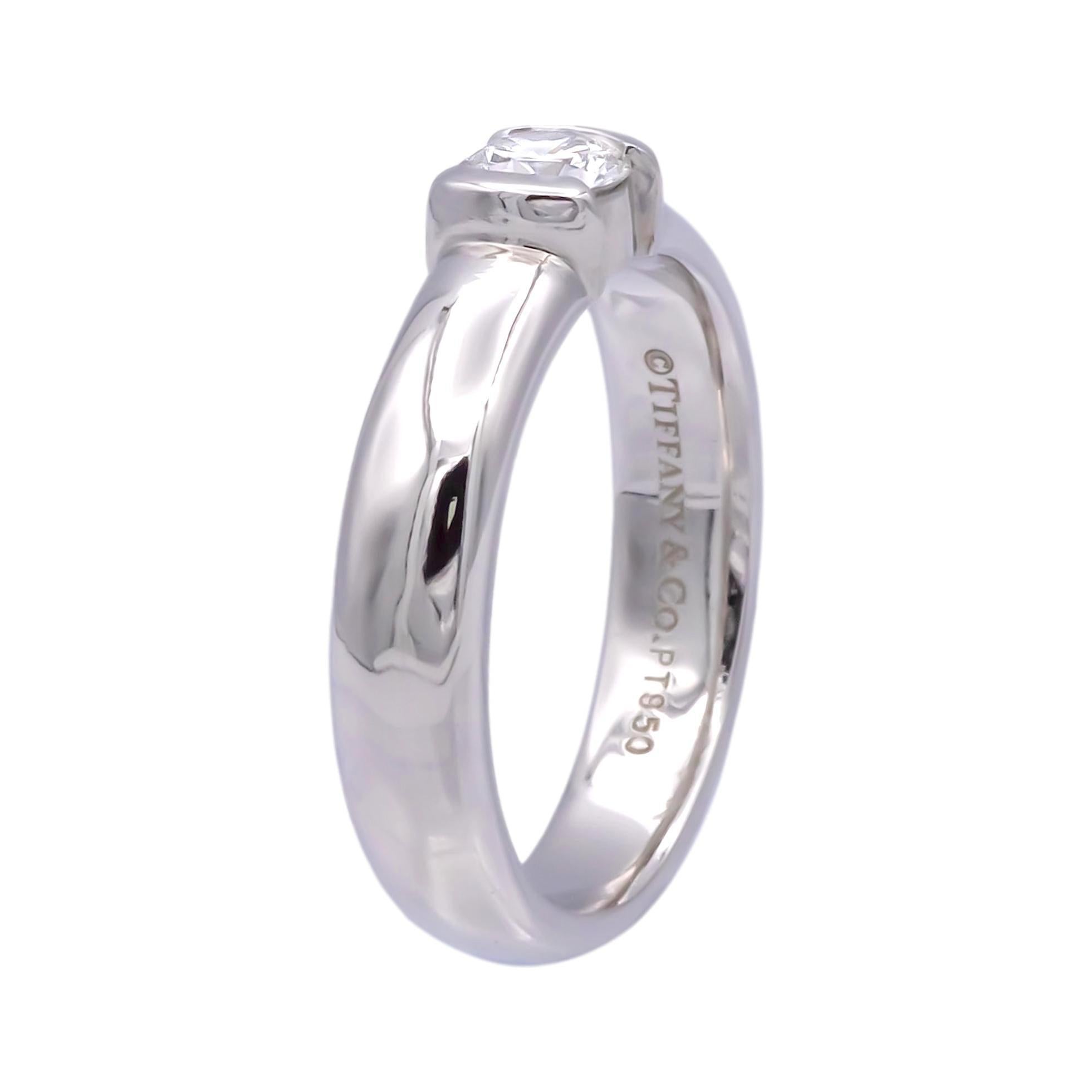 Tiffany and Co. engagement ring from the Etoile collection finely crafted in platinum featuring a round brilliant cut diamond center weighing 0.29 cts. G-H color , VVS1-VVS2 clarity set in a half bezel setting. The original Tiffany certificate for