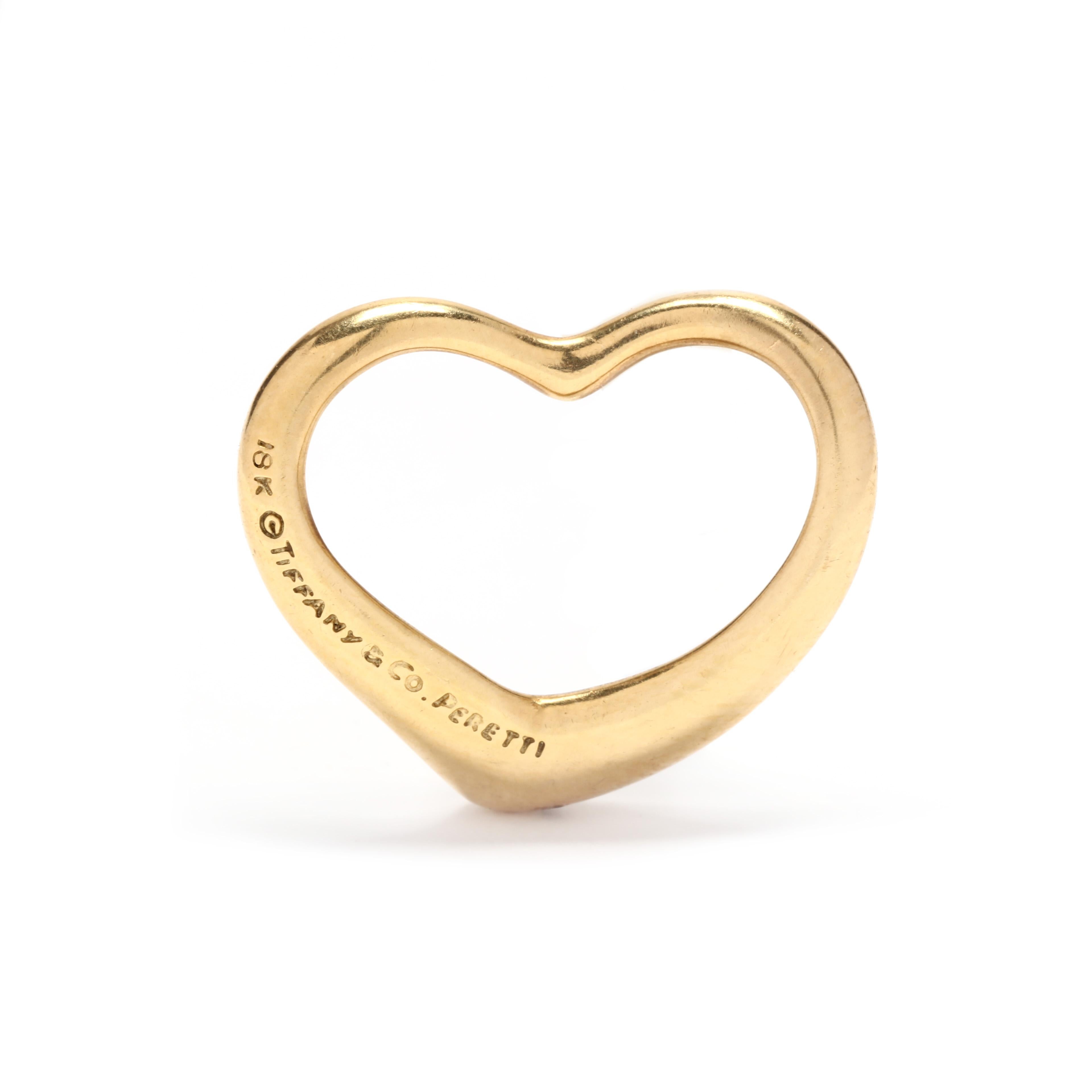 Une breloque de cœur en or jaune 18 carats conçue par Elsa Peretti pour Tiffany and Company. Ce charme présente un motif de cœur ouvert qui peut être ajouté à n'importe quelle chaîne ou corde !

Longueur : 3/4 po.

Largeur : 11/16 in.

Poids : 2,50