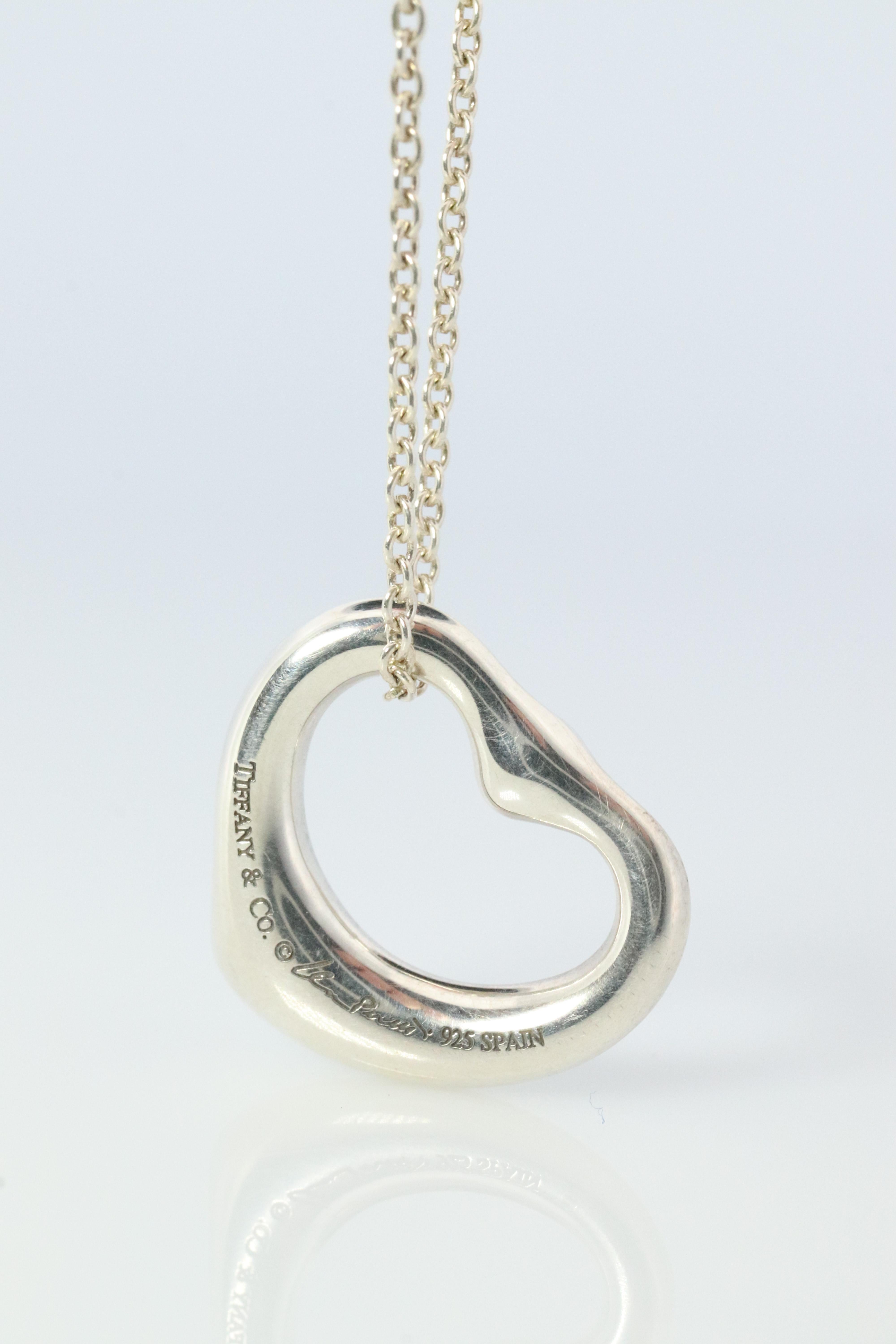 Genuine Tiffany and Co.  Elsa Peretti Heart Pendant 

Sterling silver with a bezel set Pink Sapphire.

Minor signs of wear. Will come with Tiffany pouch.

Details
13mm by 16mm Heart Pendant
2mm pink sapphire