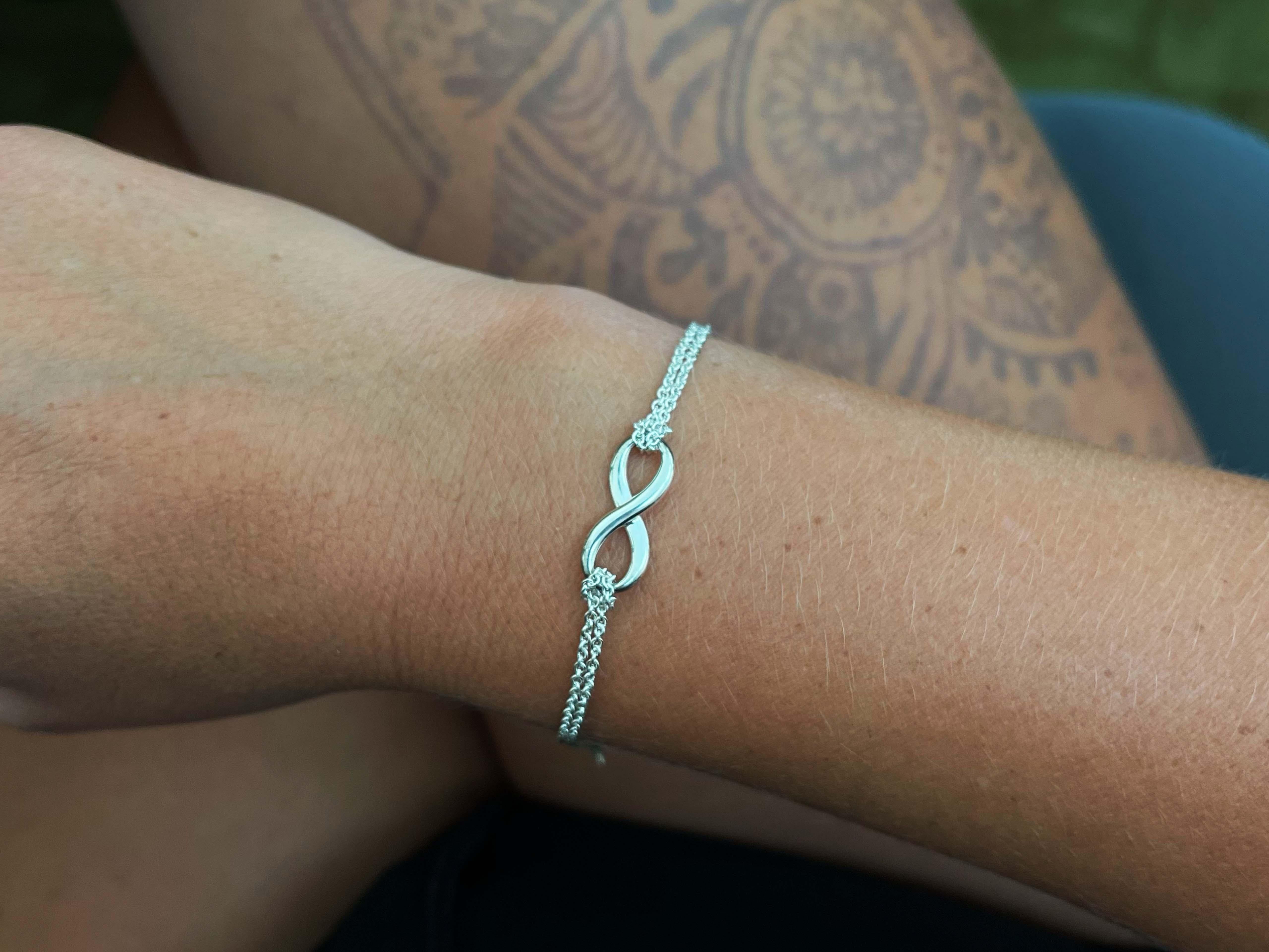 Tiffany Infinity is a powerful symbol of continuous connection, energy and vitality. The addition of endlessly looped double chains echoes the infinite nature of the design.
​
​
Item Specifications:

Brand: Tiffany & Co.

Metal: Sterling