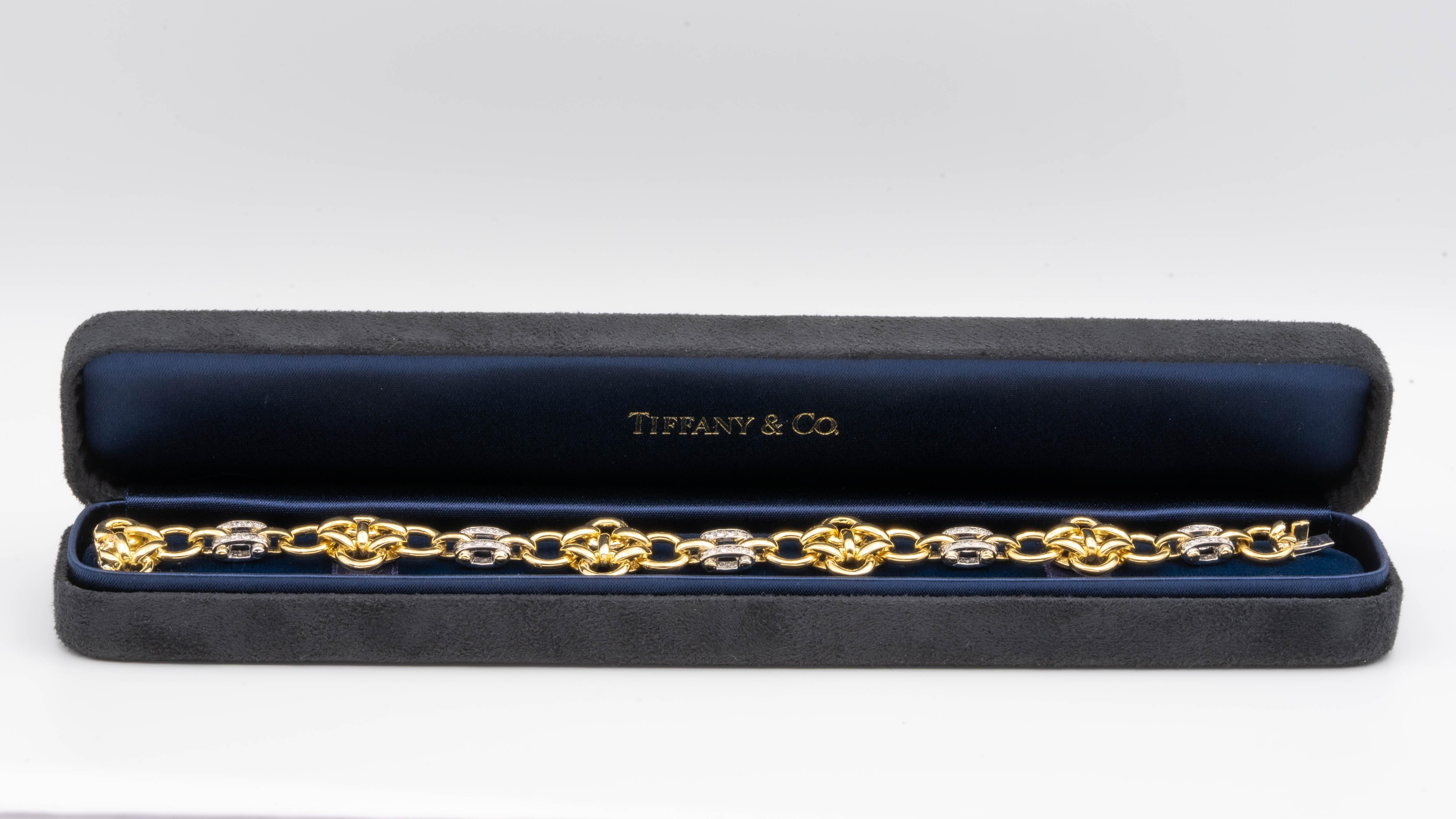This Tiffany and Co. bracelet is a lot heavier than it looks, and has a very satisfying heft to it. It's finely crafted in 18 Karat gold with Quatrefoil round yellow gold links, spaced by white gold bars. The double row channel style bars are set