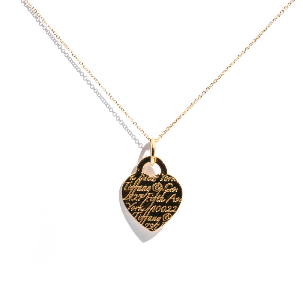 18 carat yellow gold Tiffany and Co Notes Heart Pendant and Tiffany and Co Chain is threaded on a Tiffany and Co 18 carat yellow gold chain. Tiffany and Co Notes Heart Pendant has the Tiffany and Co signature script on the front. The Tiffany and Co