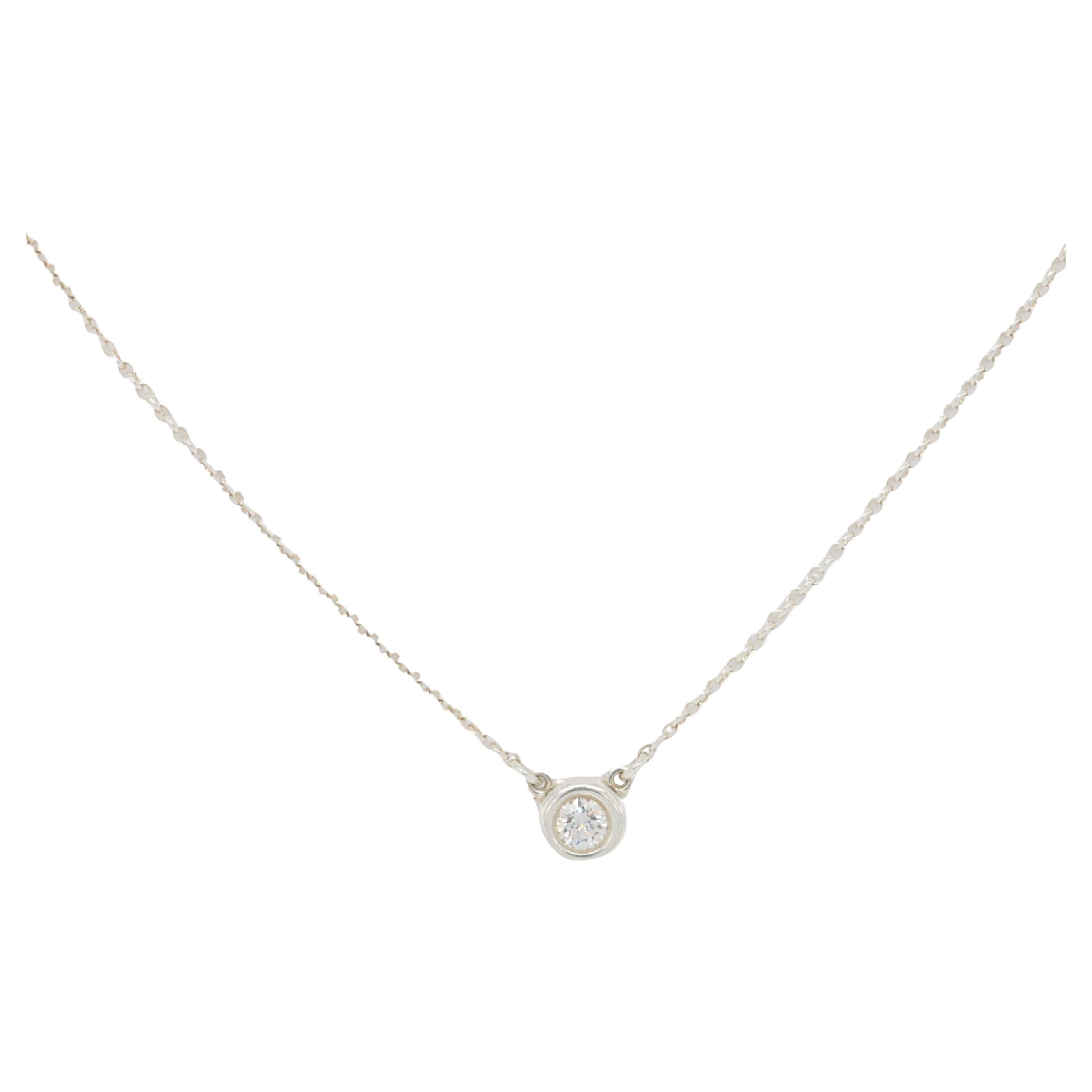 Tiffany & Co. diamonds by the yard pendant necklace designed by Elsa Peretti finely crafted in sterling silver featuring a bezel set round brilliant cut diamond weighing 0.10 cts. G Color VS clarity hanging off a 16