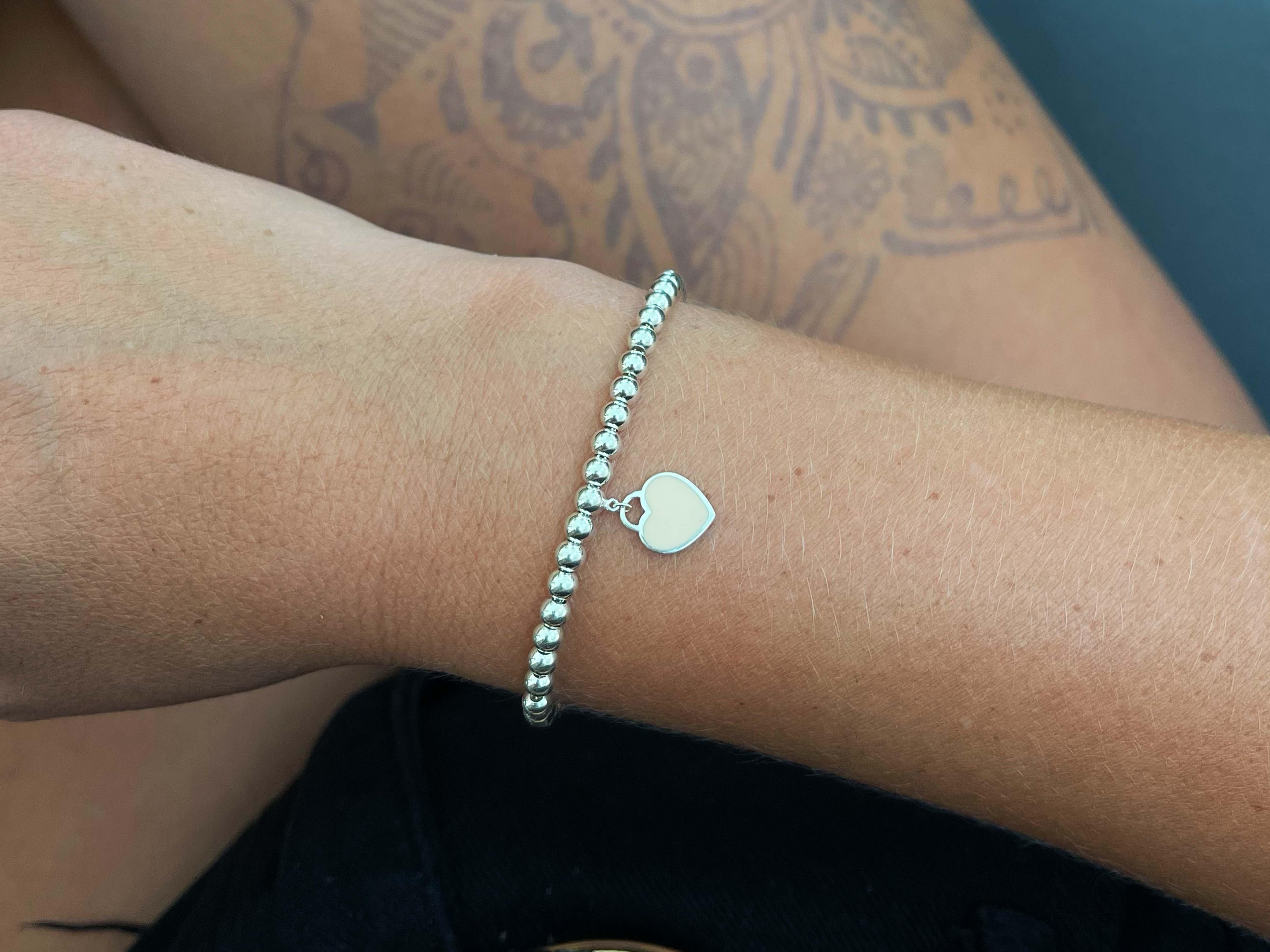Inspired by the iconic key ring first introduced in 1969, the Return to Tiffany collection is a classic reinvented. This elegant bead bracelet features an engraved tag with a pink enamel finish, evoking a subtle femininity.
​
​Item