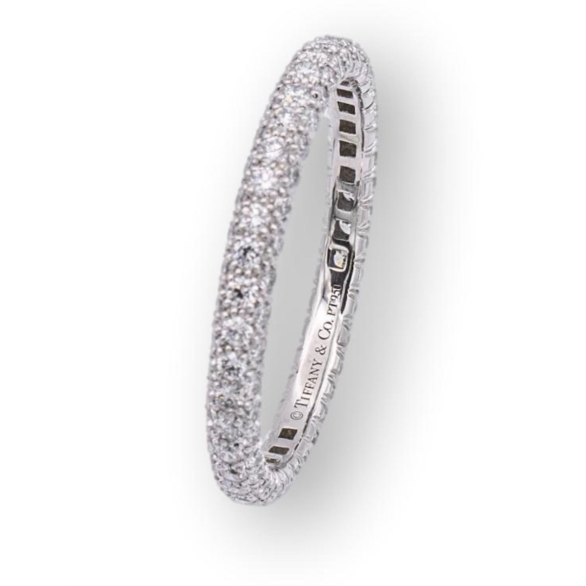 Tiffany & Co. pave band ring from the Etoile collection finely crafted in platinum with 120 round brilliant cut diamonds bead set all the way around weighing 1.20 carats total weight, E-F color , VS1-VS2 clarity. The band features 3 rows of diamonds