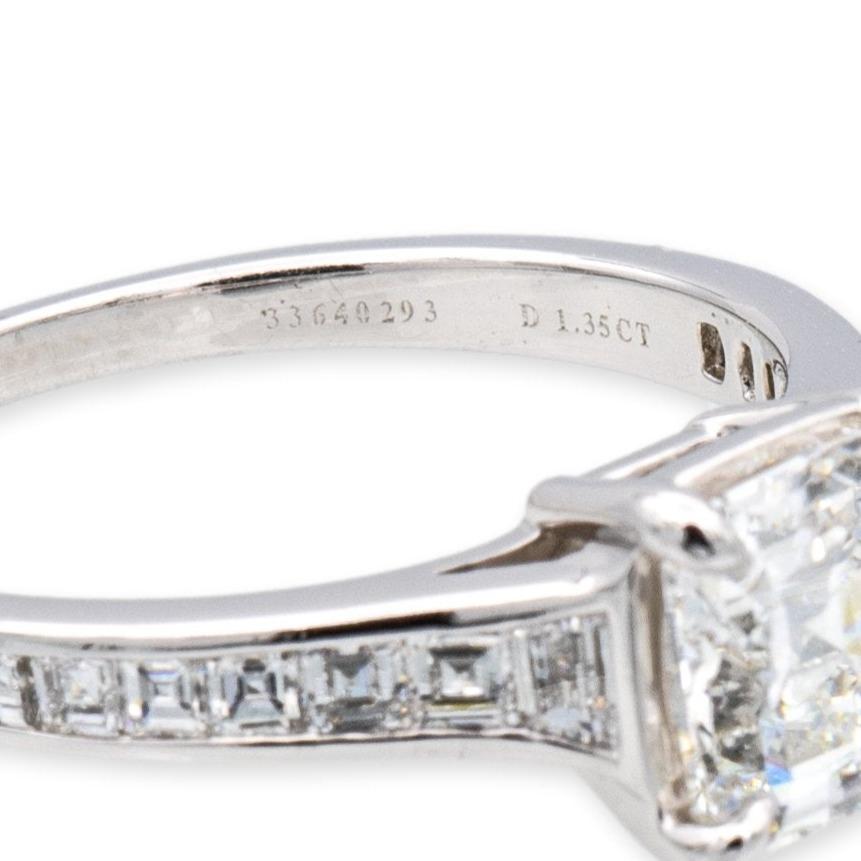 Tiffany & Co. engagement ring from the Legacy diamond collection finely crafted in platinum featuring a cushion modified brilliant center weighing 1.35 carats H color and VVS2 clarity adorned with invisible set square faceted diamonds going halfway