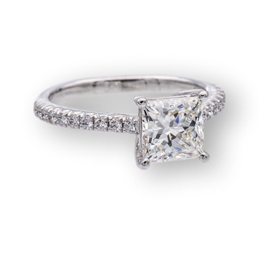 Tiffany & Co. engagement ring from the Novo collection finely crafted in platinum featuring a princess cut brilliant diamond center weighing 1.09 carats , H color , VVS2 clarity set in a 4 prong basket setting adorned with 16 bead set round