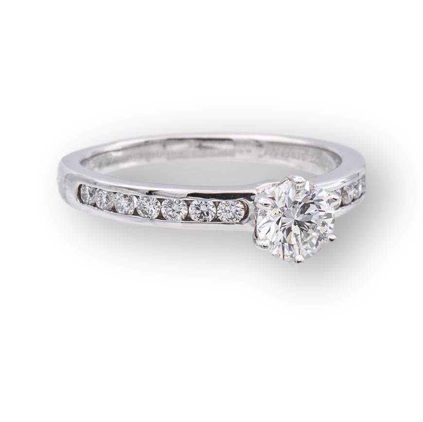Tiffany and Co. Diamond Engagement ring with a channel set diamond band featuring a 0.50 ct. round brilliant diamond center F color VS2 clarity finely crafted in Platinum. Center diamond is flanked by 7 channel set round brilliant cut diamonds on