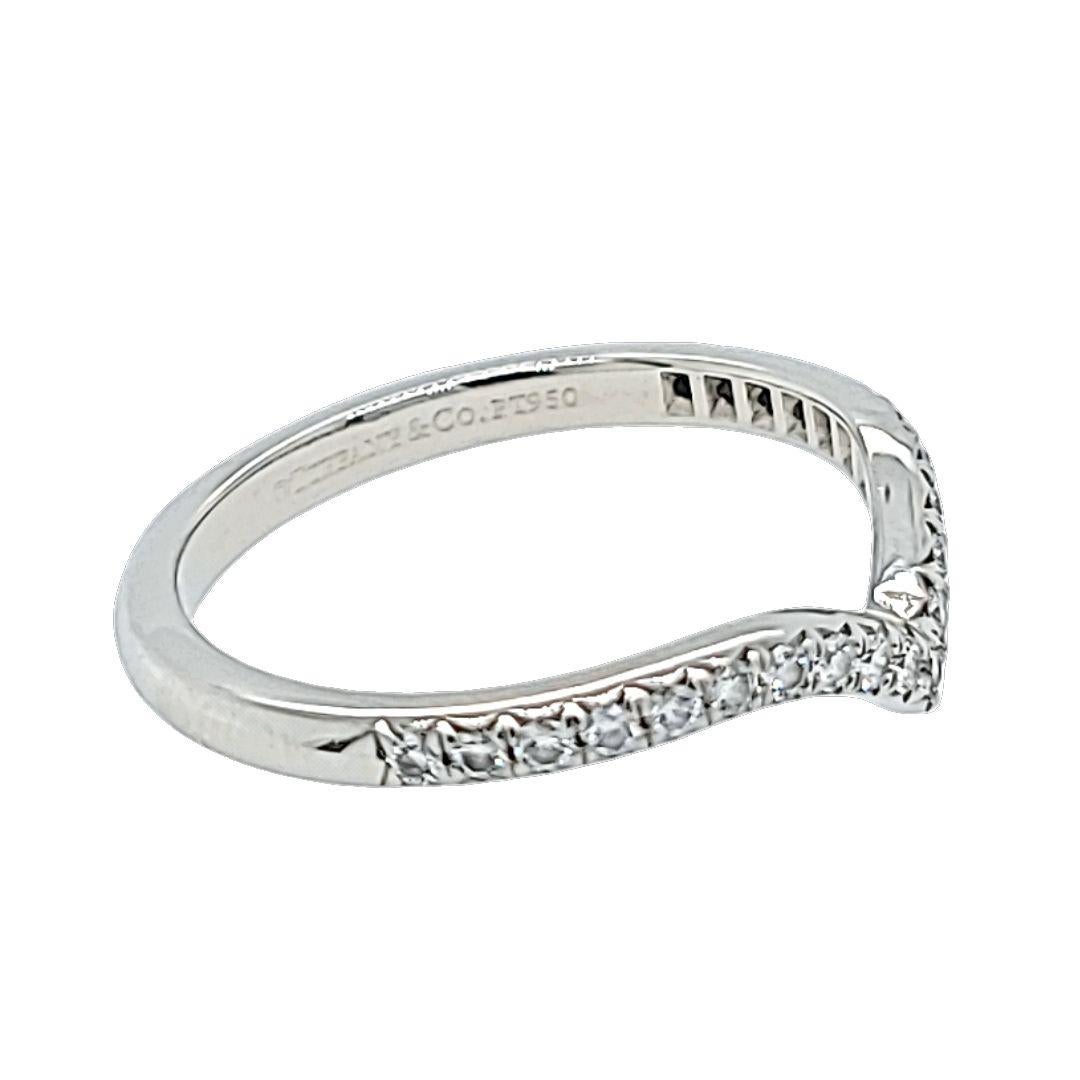 Conçue pour s'emboîter avec votre bague de fiançailles, cette bague de Tiffany & Co. La bague en platine Soleste Curved V est ornée de 21 diamants ronds de taille brillant, de pureté VS et de couleur G, totalisant 0,17 carats. Taille du doigt 5.75.